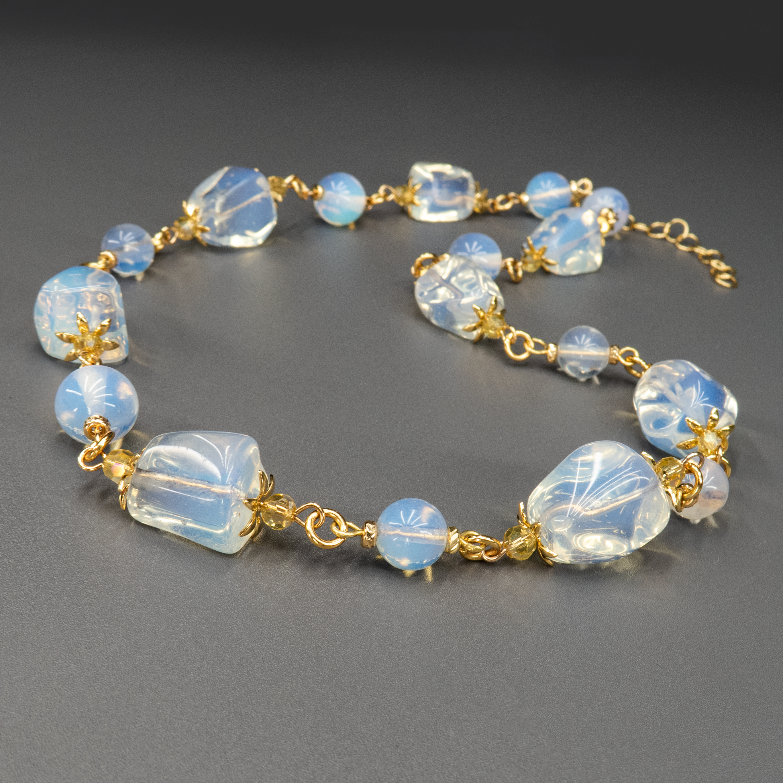 ענק עדין ובעל נוכחות – שילוב של מונסטון בגווני לבן־כחלחל עם אבני אופליט בגימור חלבי וזוהר פנימי. התוצאה היא תכשיט מלא אור, תחכום וקסם טבעי. כל אבן מקרינה עדינות שקטה, ומתאימה לנשים שמבקשות לשלב בין אלגנטיות ורוחניות בלבושן היומיומי או לאירוע מיוחד.

