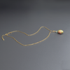 A necklace with a bead pendant in shades of green