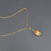 A necklace with a bead pendant in shades of green