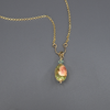 A necklace with a bead pendant in shades of green