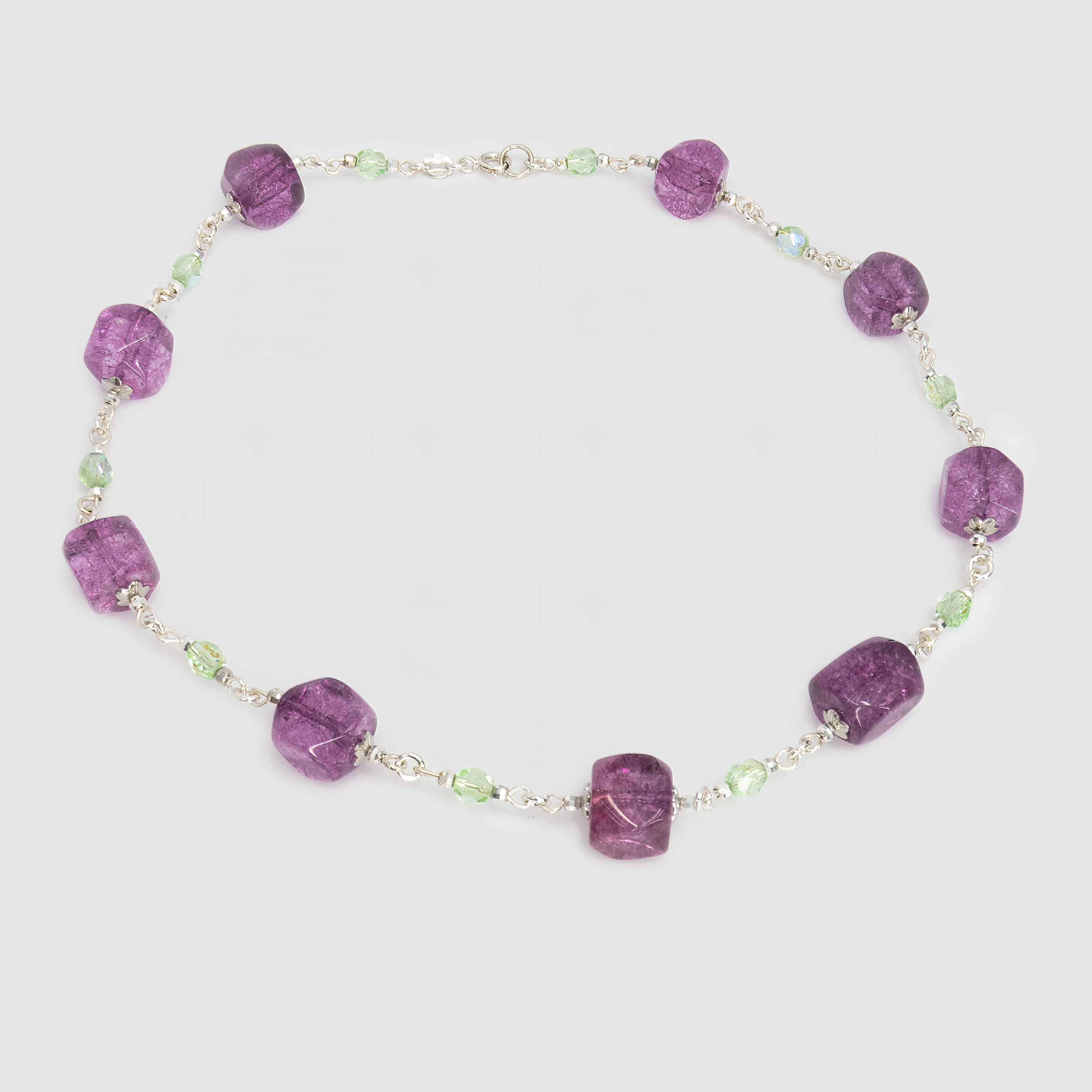 ענק מרהיב שמשלב אבני זכוכית, קריסטלים או מינרלים בגווני ירוק וסגול – צבעים שמתחברים לריפוי, אינטואיציה ופריחה פנימית. האבנים הגדולות משובצות בקומפוזיציה מתחלפת של גוונים כהים ובהירים, מה שמעניק לשרשרת תנועה חיה. תכשיט ייחודי שמחמיא במיוחד ללבוש חלק בצבעים ניטרליים.

