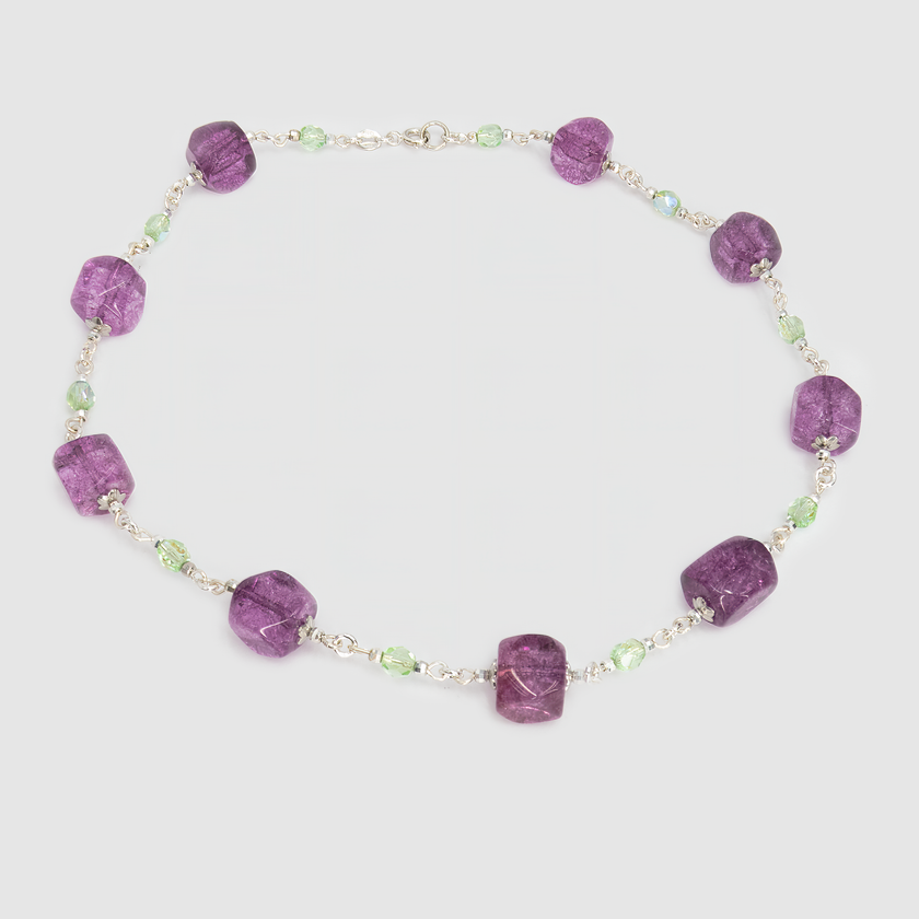 ענק מרהיב שמשלב אבני זכוכית, קריסטלים או מינרלים בגווני ירוק וסגול – צבעים שמתחברים לריפוי, אינטואיציה ופריחה פנימית. האבנים הגדולות משובצות בקומפוזיציה מתחלפת של גוונים כהים ובהירים, מה שמעניק לשרשרת תנועה חיה. תכשיט ייחודי שמחמיא במיוחד ללבוש חלק בצבעים ניטרליים.

