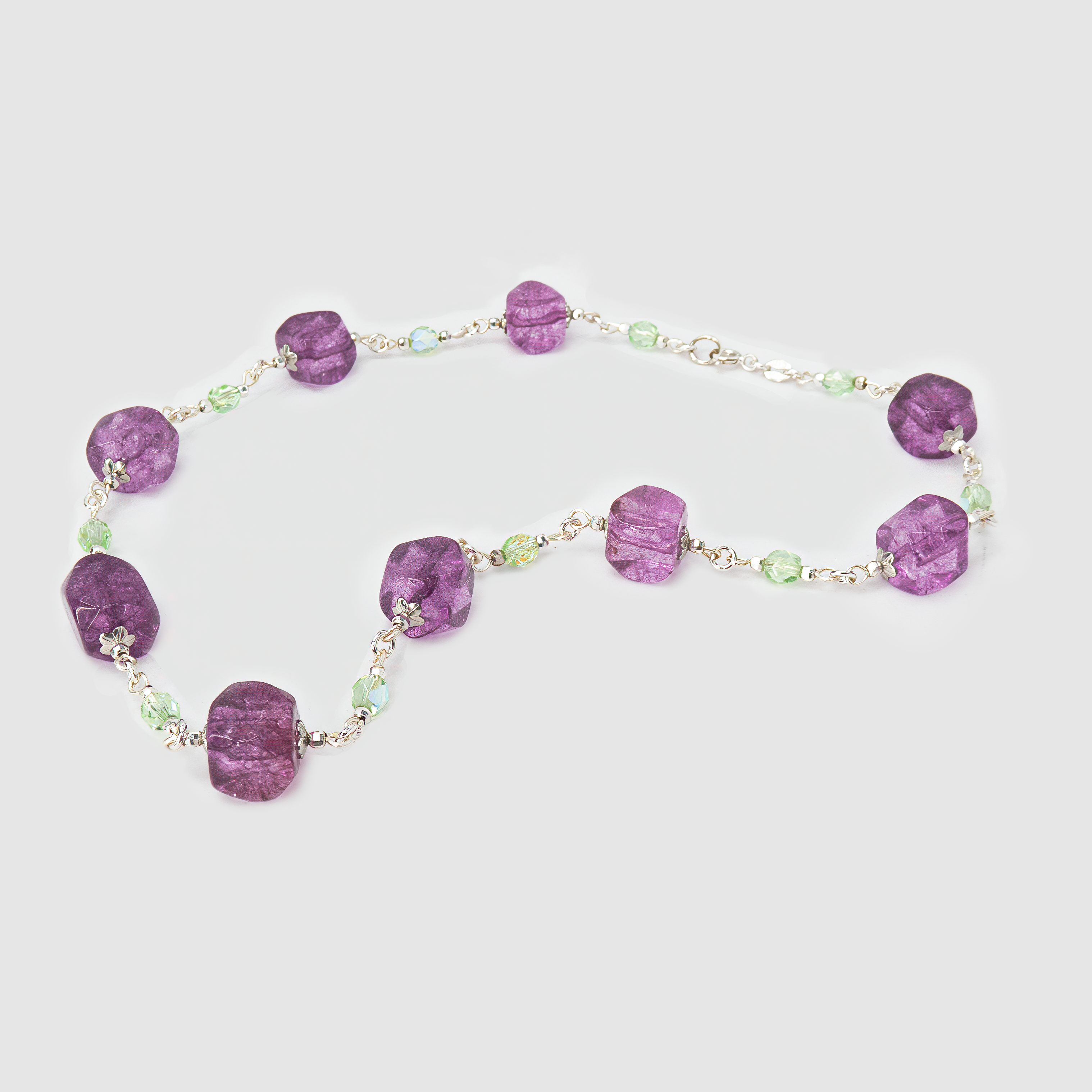 ענק צבעוני בעבודת יד עם אבנים בגווני סגול עמוק וירוק אמרלד, משלב בין שני צבעים שמסמלים רוחניות וצמיחה. האבנים מסודרות בקומפוזיציה הרמונית שיוצרת מראה בולט אך הרמוני, כמו שילוב בין פריחת לילך לבין עלווה טרייה. תכשיט מיוחד שמתאים לאירועים חגיגיים, או לכל מי שאוהבת להוסיף נוכחות צבעונית עם משמעות לכל הופעה.

