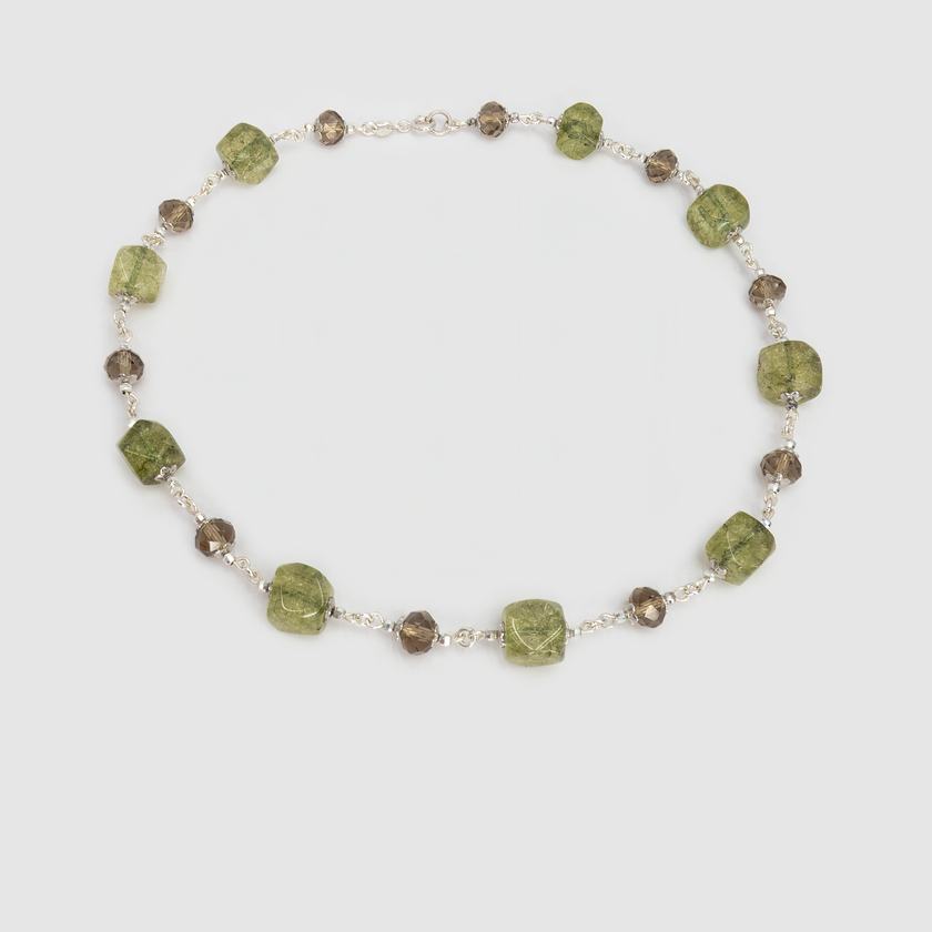 תכשיט בהשראת יערות ירוקים ואדמת טרה קוטה – ענק אבנים בעבודת יד בגווני ירוק-חום עמוקים. אבנים חלקות ואטומות לצד כאלה עם שקיפות עדינה מעניקות עניין חזותי ומרקם עשיר. הענק מעניק תחושת חיבור לאדמה, יציבות ורוגע, ומוסיף טאץ' חם וטבעי לכל הופעה.

