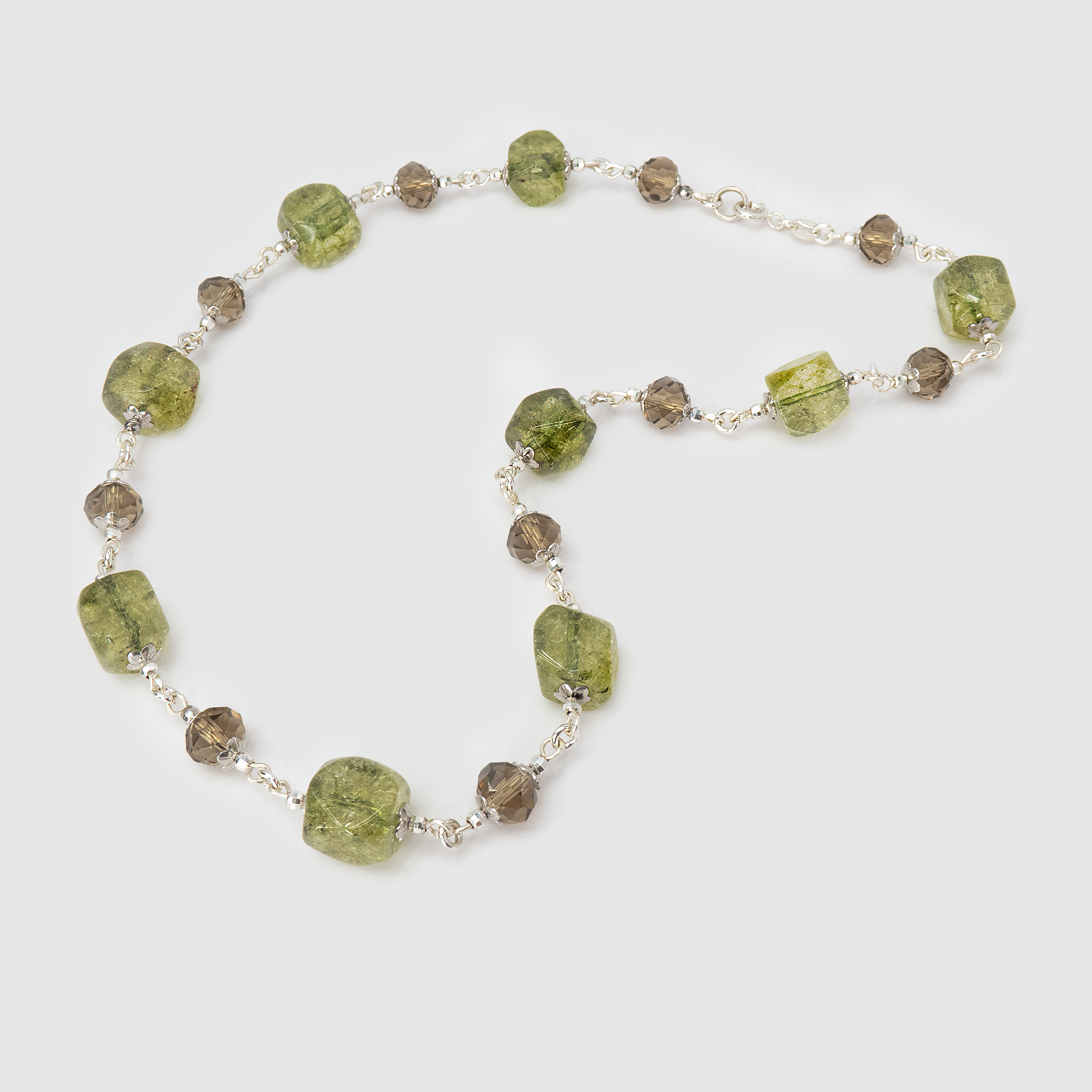 ענק בעבודת יד בגווני ירוק זית, חום אדמדם ואוקר חם – תכשיט שמזכיר נוף סתווי או יער בראשית. האבנים משתלבות זו בזו בגוונים אורגניים, חלקן שקופות קלות וחלקן אטומות בטקסטורה טבעית. התוצאה – תכשיט חם, שורשי ומעוצב בקפידה, שמתאים למראה בוהו-שיק אלגנטי, ליום ולערב.

