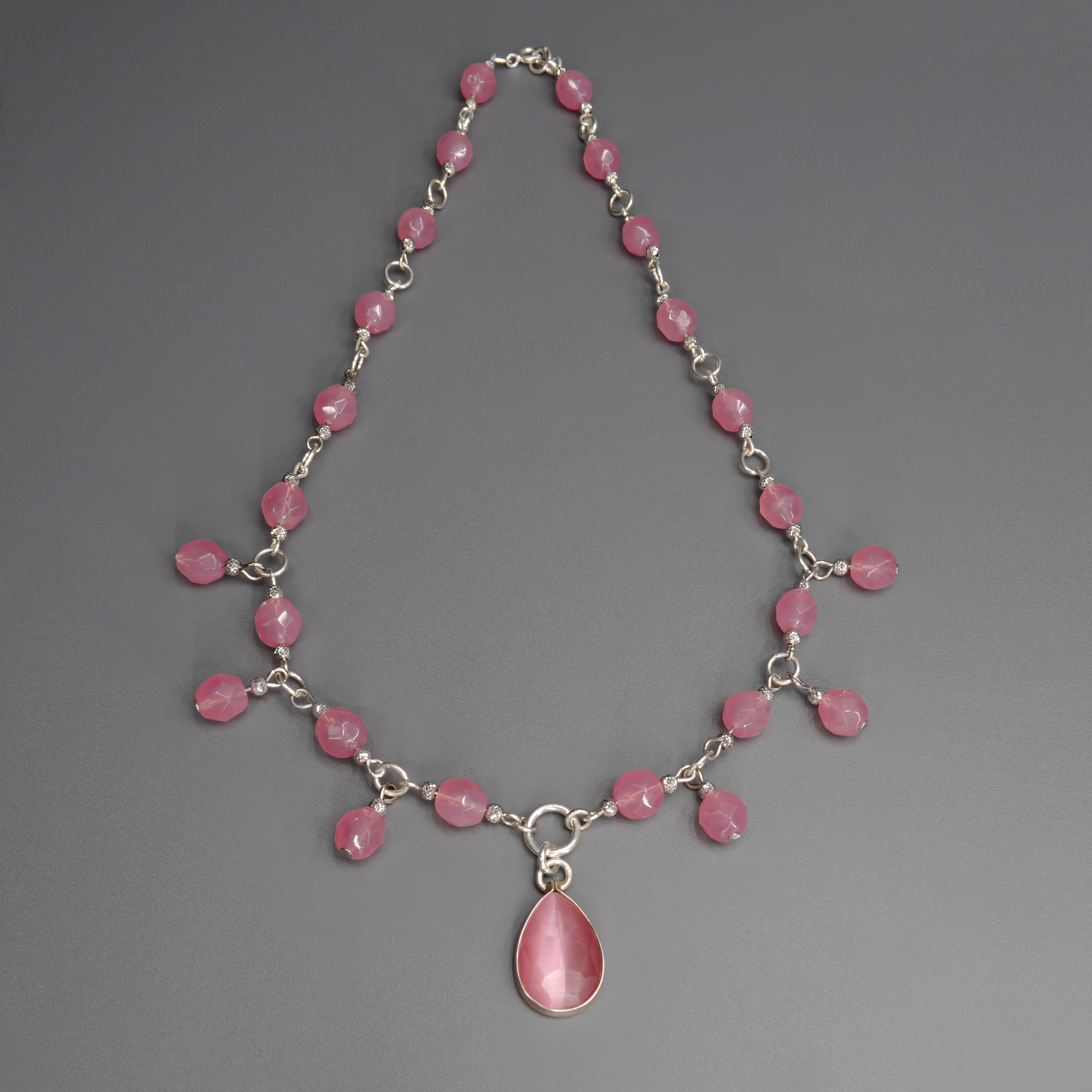 תכשיט שמזכיר זריחה רכה – צבעי ורוד משתנים עם אור ועיבוד עין חתול שמעניק תחושת תנועה מתמדת. מתאימה במיוחד לשמלות ערב, חולצות בהירות או כל לוק שרוצה טאץ’ של רוך ונשיות.