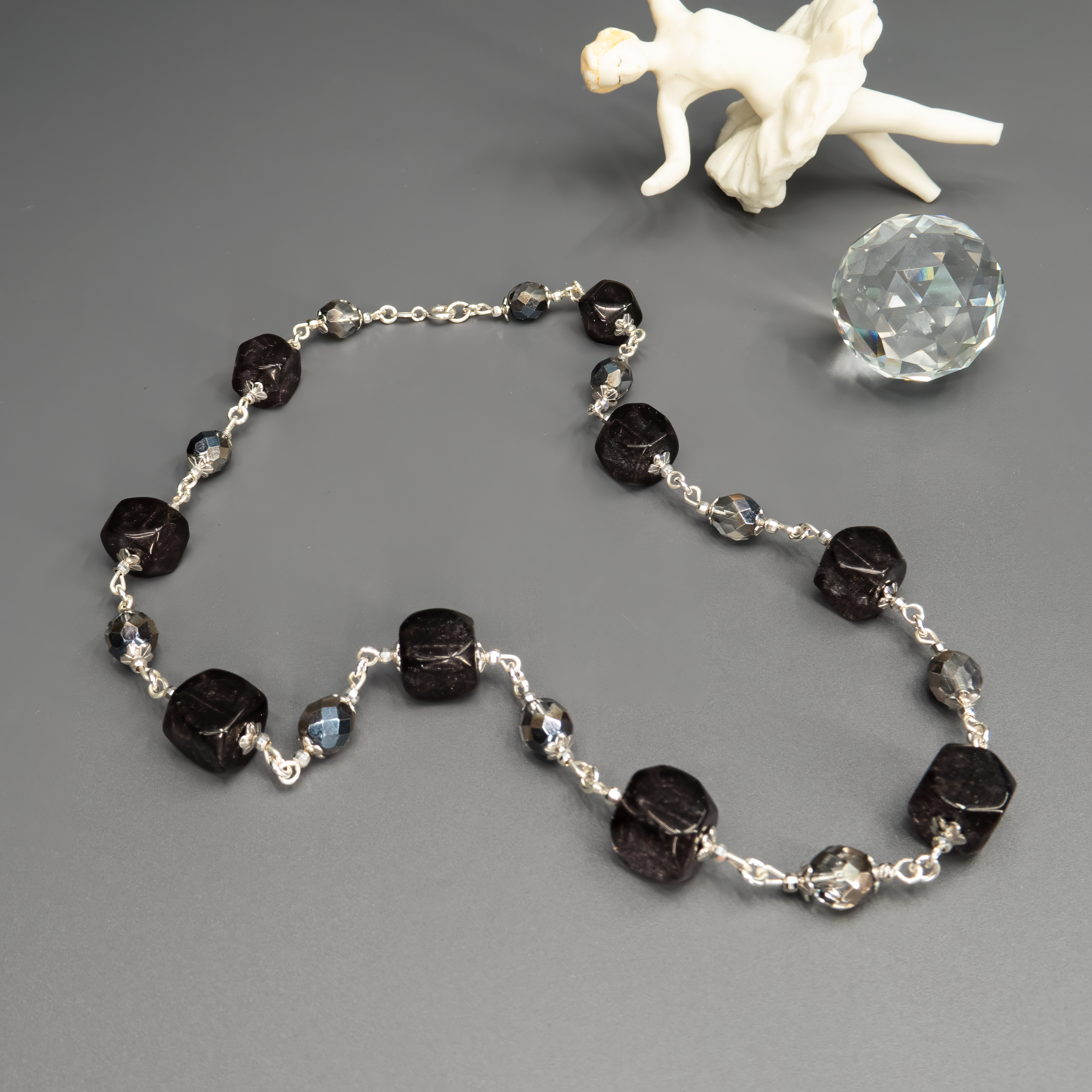 שרשרת בעיצוב מודרני עם אבני חן בגווני אפור משתנים – מהבהיר והענוג ועד הכהה והמתכתי. השילוב יוצר מראה אורבני, חכם ומדויק, שמבליט את קווי הפנים ומעניק תחושת רוגע ועוצמה שקטה. תכשיט ורסטילי שמתאים לכל עונה, ולנשים שאוהבות צבעים ניטרליים עם אופי.

