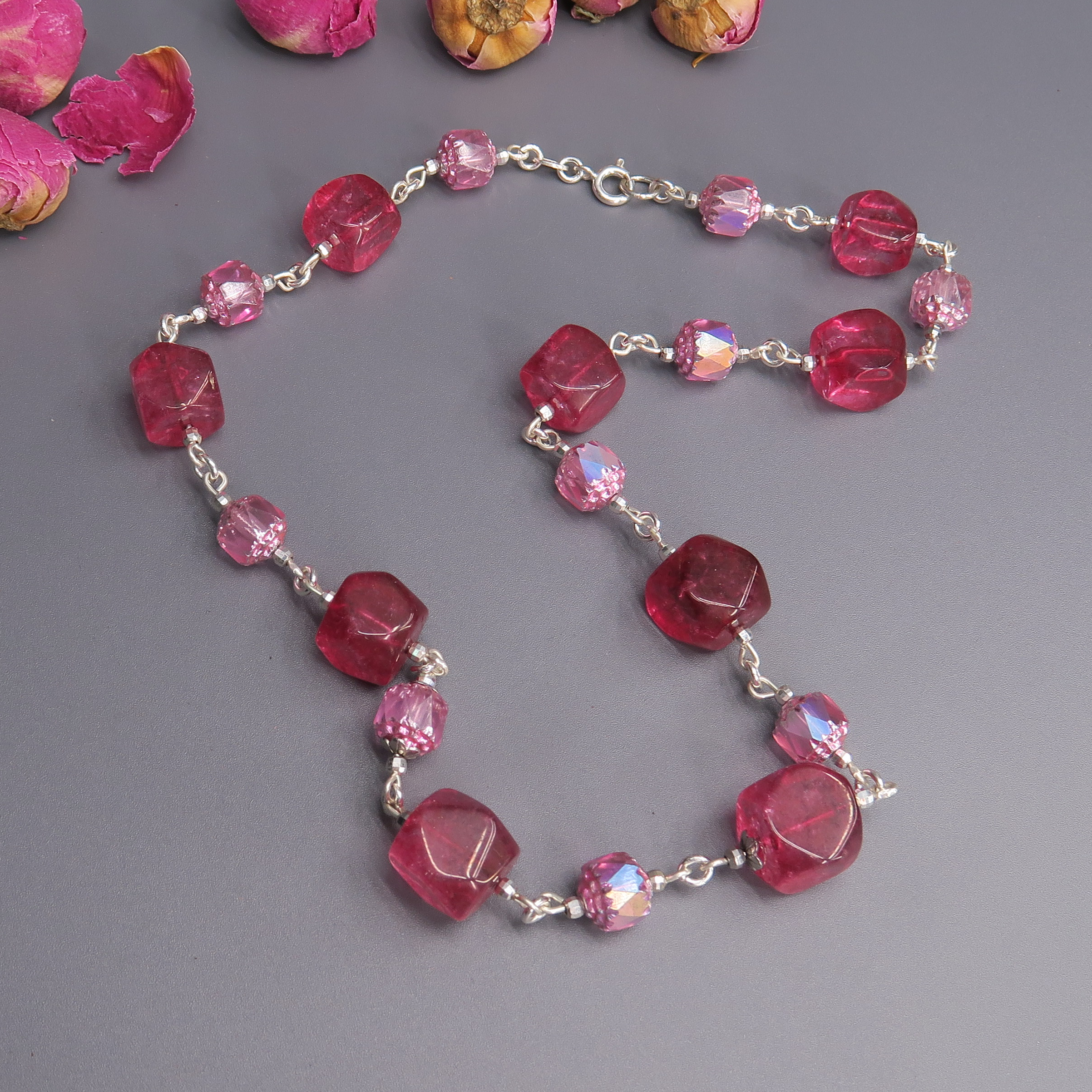תכשיט בעבודת יד המשלב צבעים דרמטיים ורומנטיים – ורוד בהיר ובורדו עשיר, בסקאלה צבעונית שמשדרת עומק רגשי ונשיות חזקה. האבנים בגימור מלוטש ותחושת משקל קל ונעים, מונחות על הצוואר בצורה זורמת שמחמיאה לכל גוון עור. זוהי שרשרת שמדברת בשפה של יופי עם משמעות: עדינות פוגשת עוצמה, כמו פרח רך עם ליבה בוערת. מתאימה להשלמת מראה אלגנטי, ליצירת נוכחות שקטה אך בלתי נשכחת.

