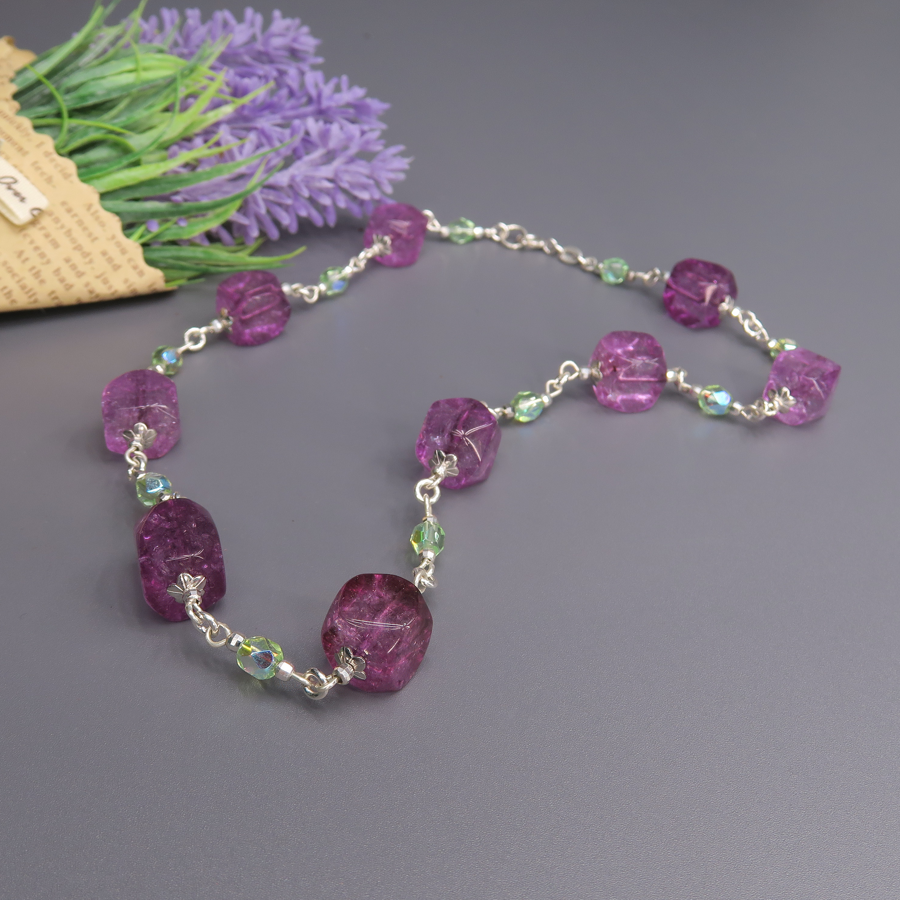 שרשרת בגווני ירוק עדין וסגול עשיר, עם שילוב אבנים חלקות ומלוטשות לצד מרקמים טבעיים. משחקי האור בין החרוזים מעניקים לשרשרת חיים ודינמיות. תכשיט שמתאים גם למראה קז'ואל וגם לשמלה שחורה קטנה, כתוספת של צבע וייחוד.

