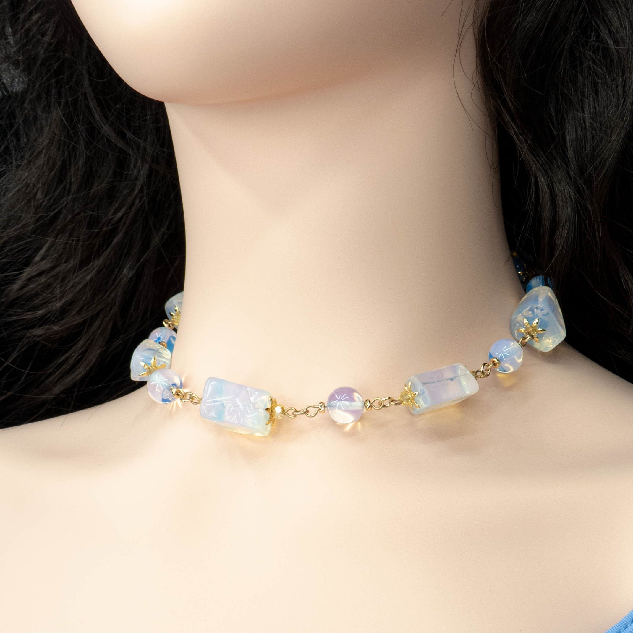 ענק מונסטון־אופליט שנראה כאילו נאסף מאור הירח. האבנים בגדלים משתנים, חלקן שקופות למחצה וחלקן בגימור חלבי, יוצרות יחד משחק של צבעים פנימיים עדינים ותנועה קלילה. תכשיט שעוטף את הצוואר באור פנימי רך, אידיאלי לנשים עם נשמה אמנותית ורוח חופשית.

