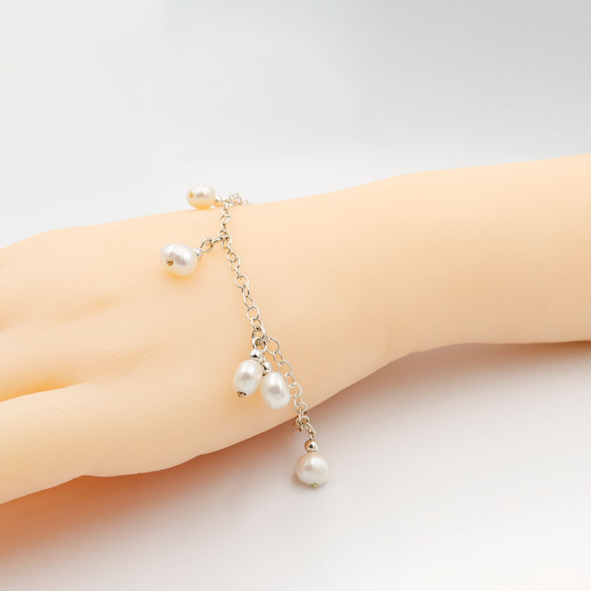 צמיד כסף עדין עם פנינה לבנה – שילוב מושלם בין פשטות טבעית לאלגנטיות נצחית. הפנינה, בגוון לבן רך, משובצת במרכז הצמיד ויוצרת מראה נקי ורך. תכשיט שמתאים לכל גיל ולכל סגנון – מושלם לכלה, לשושבינות או כמתנה ליום הולדת. נוח לענידה יומיומית, וגם כתוספת מרשימה לערב. עבודת יד קפדנית מחומרי גלם איכותיים. מעניק תחושת יוקרה עם מראה נעים ולא מתאמץ.

