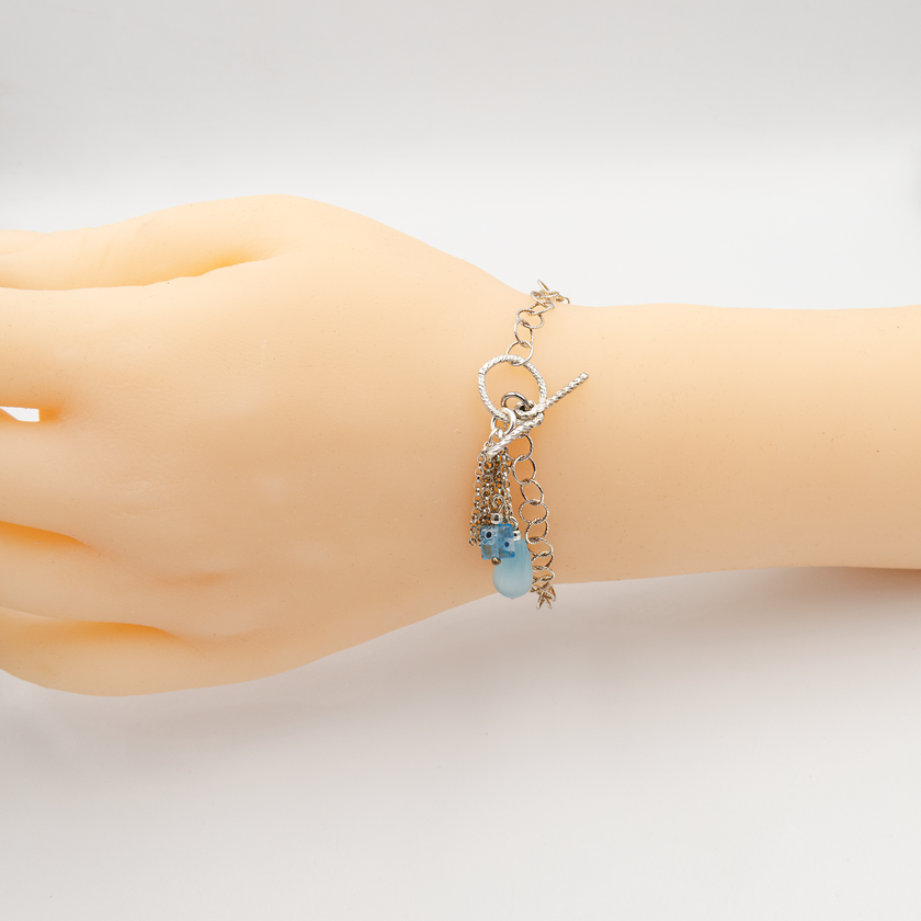 צמיד עדין ומינימליסטי מכסף סטרלינג 925 עם נגיעה של צבע – קריסטל בגוון תכלת רך שמוסיף רעננות ואלגנטיות. עיצוב נקי ומודרני שמתאים לנשים ונערות כאחד, לשימוש יומיומי או כהשלמה עדינה למראה אלגנטי. הקריסטל התכלת מוסיף נגיעה של אור וקסם, מושלם כמתנה ליום הולדת, בת מצווה או חג. משתלב נהדר עם תכשיטים נוספים, או כפריט יחיד שמעביר תחושת ניקיון וסטייל מודרני.