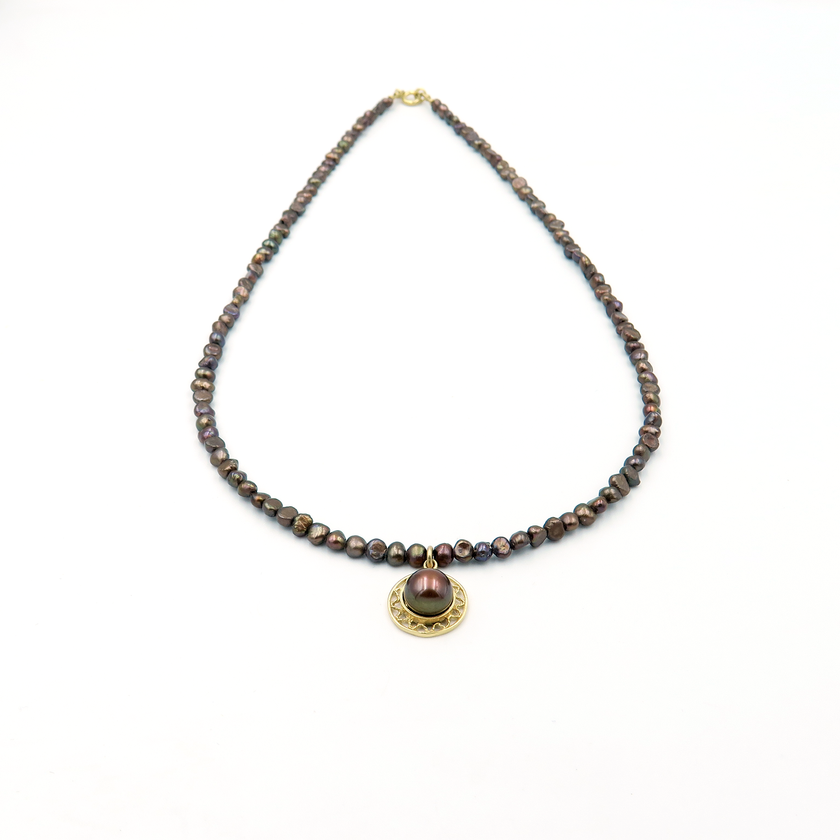 שרשרת פנינים בגווני שוקולד עשירים עם תליון מרכזי – שרשרת שמשדרת עידון עם נוכחות. הפנינים בצבעי חום, ברונזה וקוניאק יוצרים מראה עשיר בגוונים טבעיים שמתאים לכל עונה. התליון מוסיף טוויסט עדין שהופך את השרשרת לבלתי שגרתית, שמושך את העין ומשלים את המראה הכללי. השילוב בין גווני האדמה לבין הברק הפנינתי מעניק לשרשרת תחושת עושר שקט וסטייל מודרני, שמתאימים גם ליום וגם לערב. שרשרת שמתחברת לנשיות חזקה, לאהבה לפרטים ולאיזון בין עוצמה לרוך – בדיוק במידה הנכונה.