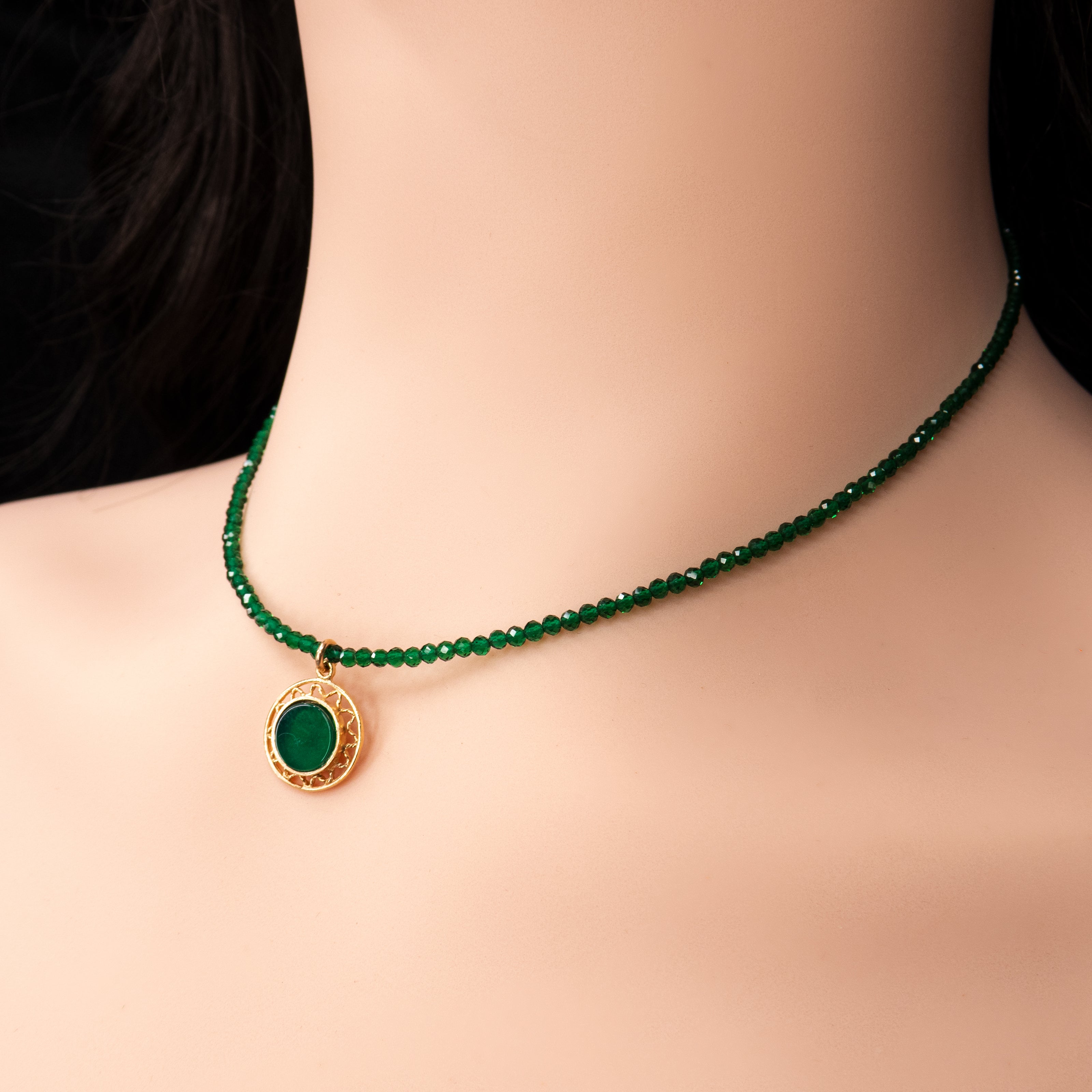 שרשרת קולר טרנדית בגוון ירוק עמוק, עם תליון עגול מוזהב במרכז. שילוב הצבעים הירוק והזהב משתלב נפלא עם בגדים בהירים, במיוחד לבן. תכשיט מושלם ללוק מינימליסטי עם נוכחות – מתאים גם למשרד וגם לאירועים. תוספת מדויקת למלתחה של כל אישה אופנתית.