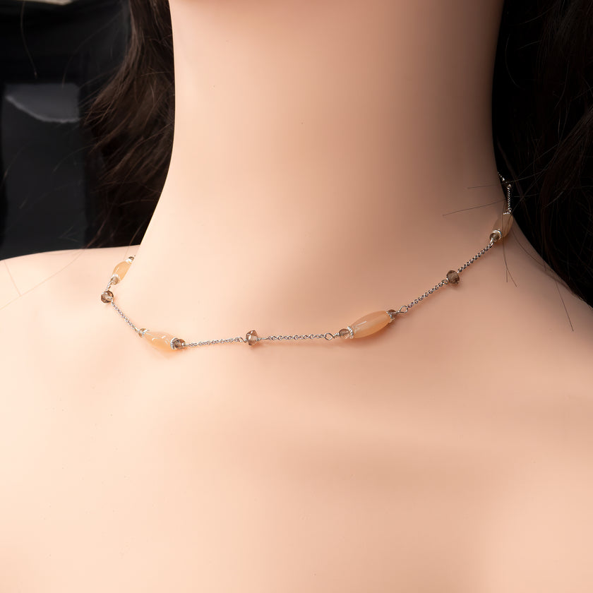 שרשרת זהב 14 קראט בעיצוב מינימליסטי ונקי, המשובצת באבני חן טבעיות של טופז ומונסטון בגוונים עדינים וקריסטליים. הטופז מבריק וזוהר, בעוד שהמונסטון מפיץ נצנוץ פנימי רך וקסום המזכיר אור ירח, המעניק לתכשיט תחושה של מסתורין וייחודיות. התכשיט מתאים לנשים שמעריכות שילוב של עכשוויות עם תחושת עומק, ומתאים הן למראה יומיומי מוקפד והן לסטייל ערב מתוחכם.