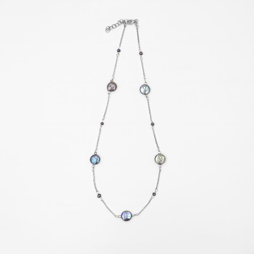 שרשרת מודרנית מכסף עם פנינים כהות טבעיות – תכשיט אלגנטי ונקי, שמשלב מראה מודרני עם עומק צבע טבעי. הפנינים העגולות בגוון אפור־כחלחל כהה משתלבות על גבי שרשרת כסף עדינה ומוסיפות לה אור עמוק עם אפקט מסתורי. העיצוב עיצוב עכשווי עם גישה על־זמנית – מתאים לנשים שמעדיפות תכשיטים מתוחכמים שאינם צועקים אך אי אפשר להתעלם מהם. השרשרת מושלמת ללבישה יומיומית אלגנטית או כבחירה מושלמת לנשים שמחפשות מראה מאוזן ואלגנטי.