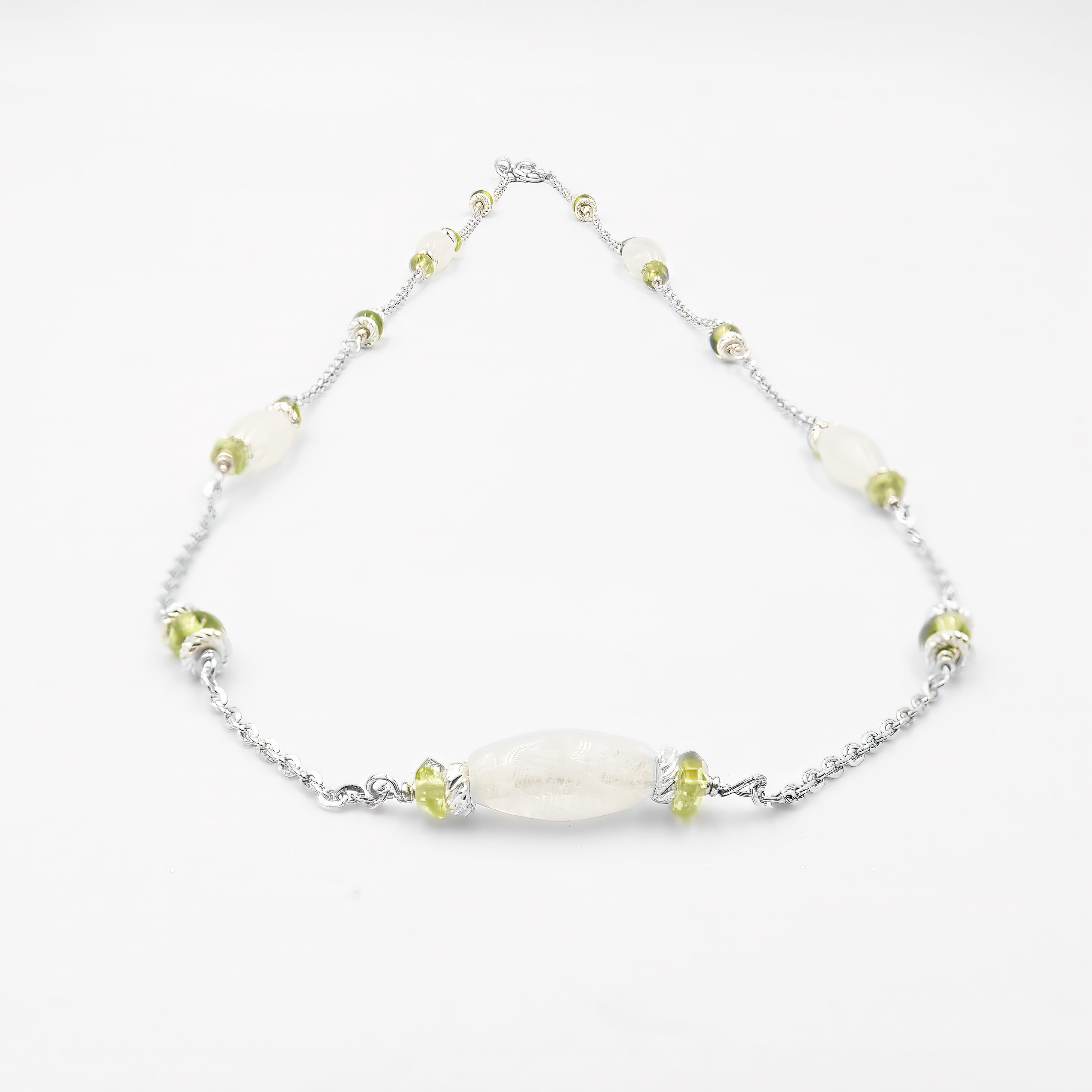 שרשרת מעודנת מזהב 14 קראט עם שילוב אלגנטי של מונסטון לבן חלבי ואוליבין ירוק רך, בעבודת יד מוקפדת. תכשיט נשי עם גוונים טבעיים, המשלב אור רך ורעננות חיה. המונסטון מביא עמו אנרגיה של אינטואיציה ועדינות, בעוד האוליבין תורם לתחושת קלילות והתחדשות. עיצוב אלגנטי ונקי שמתאים לכל סגנון לבוש – קז'ואל, בוהו או קלאסי. תכשיט מושלם כמתנה סמלית עם משמעות רגשית, רוחנית ואסתטית, בעיצוב שמשדר פשטות יוקרתית ונוכחות רגישה.