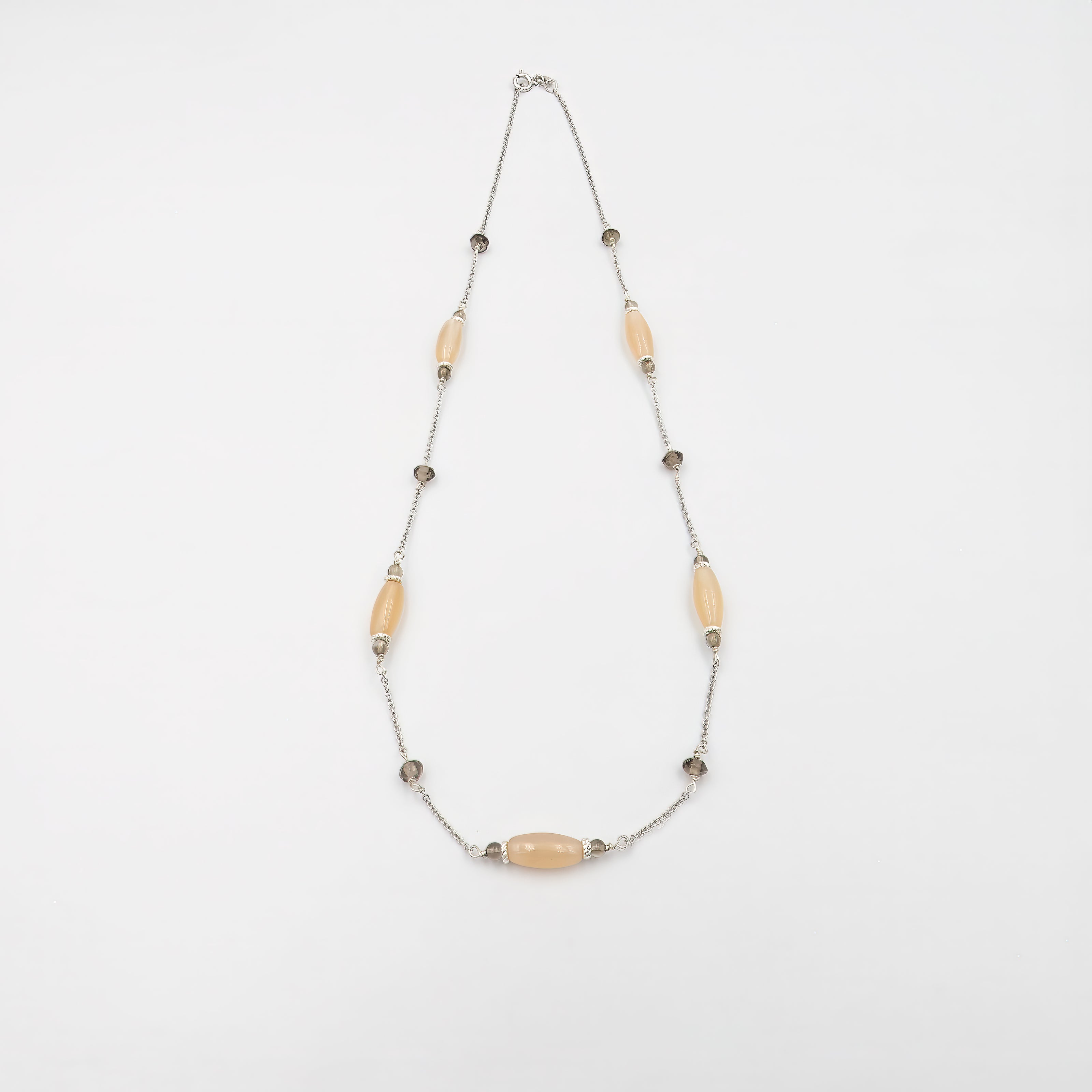 שרשרת זהב 14 קראט בעיצוב עדין ומוקפד, המשובצת בשילוב נדיר של שתי אבני חן טבעיות: טופז שקוף עם ברק קריסטלי נוצץ, ומונסטון עם נצנוץ פנינתי אופייני שמזכיר אור ירח רך ומסתורי. התכשיט משרה אווירה של זוהר טהור ורוגע, ומציע שילוב מושלם בין אור וצל, חומריות וקלילות. זהו תכשיט שמתאים לנשים המחפשות ללבוש תכשיט שמספר סיפור, מקרין רוגע פנימי ומוסיף נגיעה של יוקרה טבעית ומודרנית. השרשרת דקה ואלגנטית, מתאימה הן ליום יום והן לאירועים מיוחדים, ומדגישה כל לוק בנגיעת צבע ואור עדינה אך משמעותית.