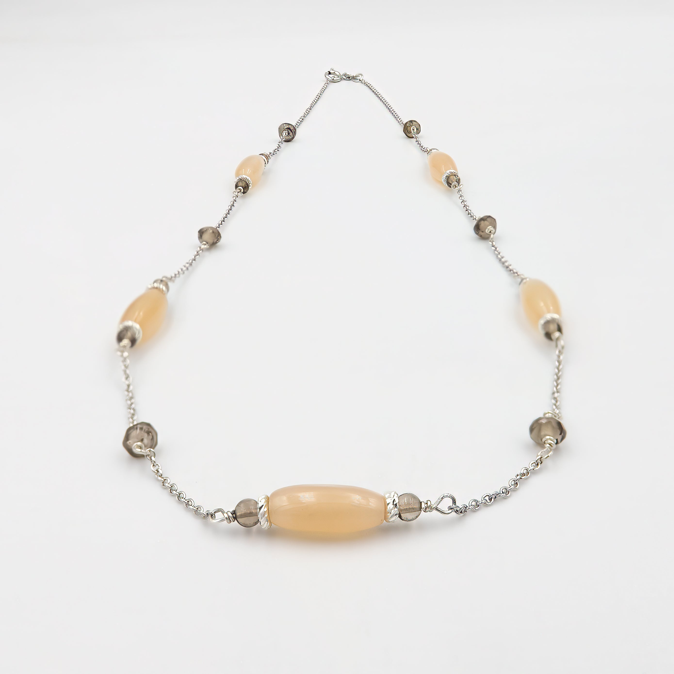 שרשרת עדינה ומרשימה מזהב 14 קראט, שבה משתלבים טופז שקוף ומונסטון פנינתי בעיצוב הרמוני ומאוזן. השילוב בין הברק הנקי של הטופז והזוהר החם של המונסטון יוצר תכשיט שמקרין חום, אור ורוגע, ומסוגל להעשיר כל מראה ביופי טבעי ואלגנטי. מתאים לשימוש יומיומי וגם לאירועים מיוחדים, כשהוא מוסיף נגיעה של זוהר עדין.