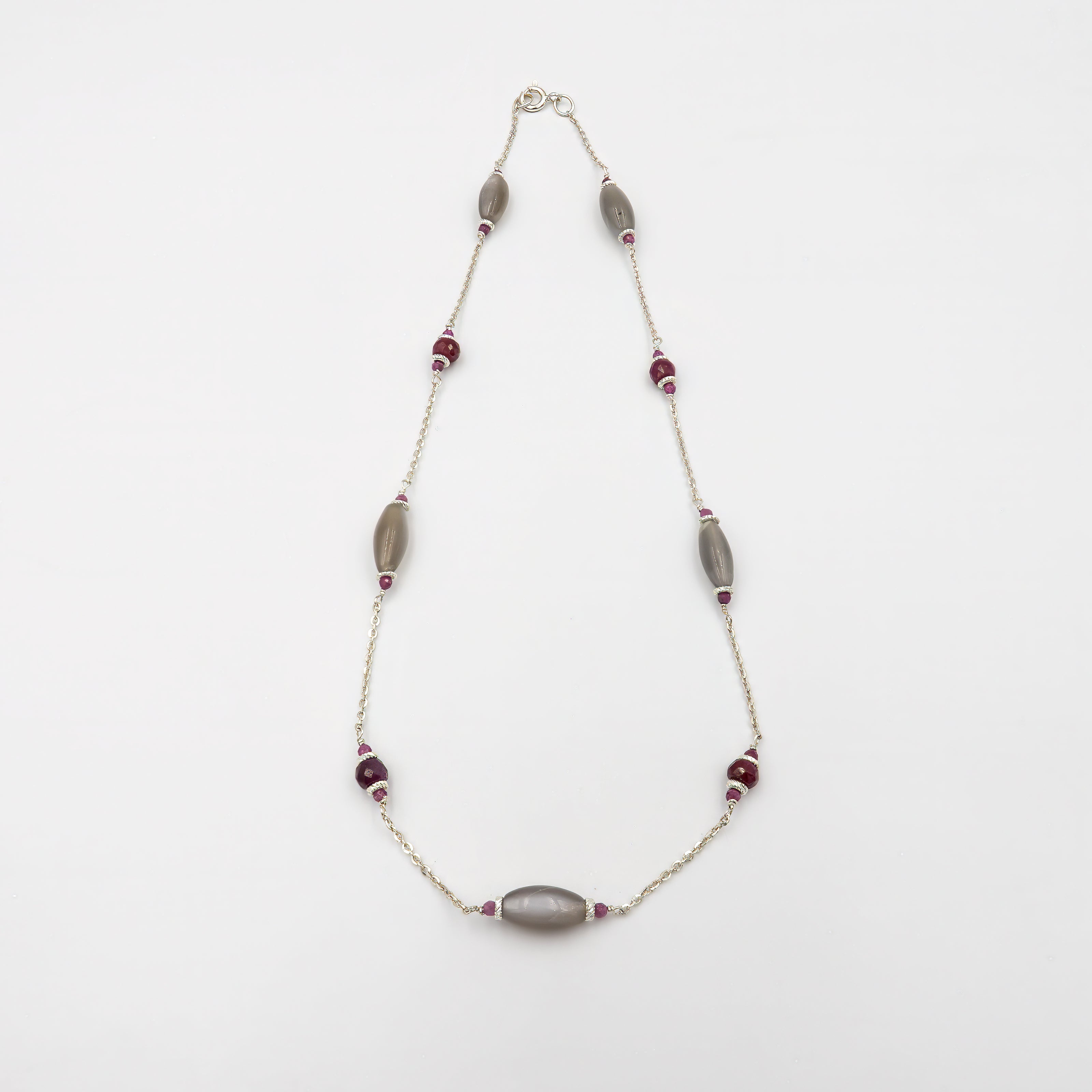 שרשרת עדינה ויוקרתית מזהב 14 קראט בעבודת צורפות מוקפדת, המשובצת באבן רובי טבעית בגוון בורדו עמוק ובאבן לברדורייט בגוון אפור-כחול עם נצנוץ אופייני ומסתורי. שילוב ייחודי שמעניק לתכשיט מראה אלגנטי, מתוחכם ורב-שכבות, מושלם לאירועים מיוחדים או כמתנה בלתי נשכחת.