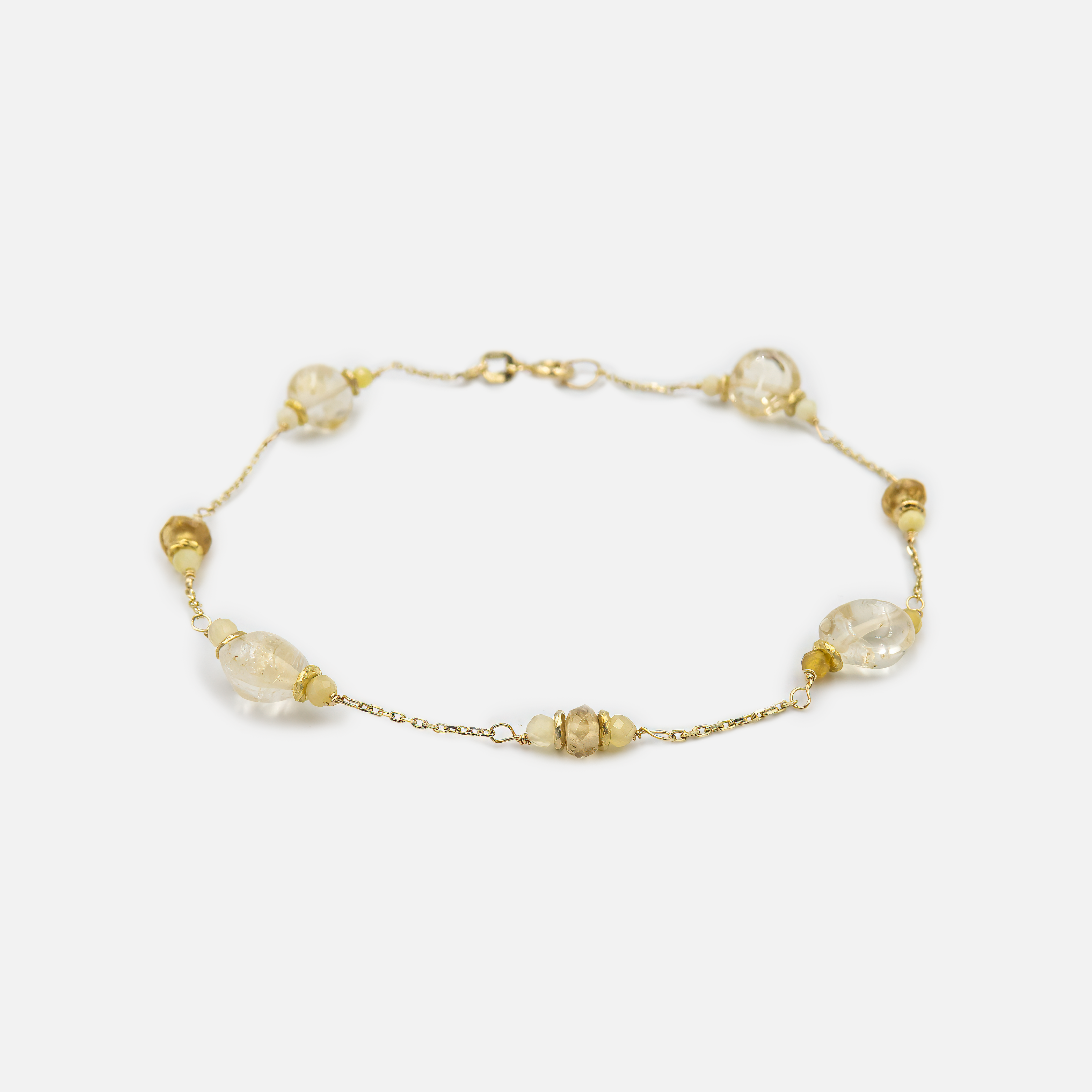 צמיד עשוי זהב 14 קראט בעיצוב אלגנטי, המשובץ בטופז שקוף ונוצץ לצד אופל צהוב בעל גוונים זהובים-פנינתיים. שילוב אבנים שמעניק לצמיד מראה זוהר אך מעודן, עם משחקי אור מרהיבים. הבחירה המושלמת למי שמעריכה תכשיטים אלגנטיים עם טוויסט ייחודי.