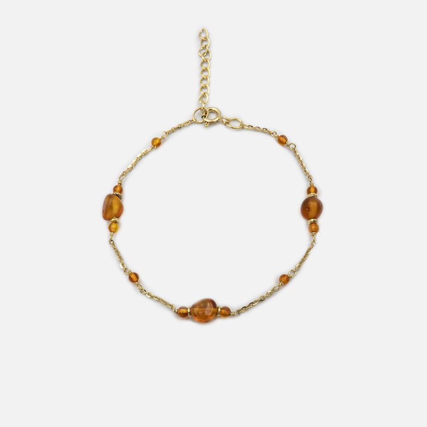 צמיד כסף מינימליסטי בעבודת יד, עם אבן ענבר טבעית בגוון חם וזוהר. עיצוב נקי וקלאסי שמתאים לאישה שאוהבת תכשיטים עדינים עם אופי. האבן מוסיפה נגיעה אורגנית ואישית – כאילו נשמרה בה טיפה של שמש מהעבר. הצמיד מושלם כמתנה ליום הולדת, תודה או רגע מרגש אחר. תכשיט נצחי שנשאר תמיד רלוונטי.