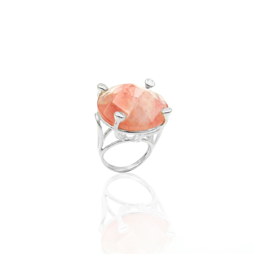 טבעת כסף בעבודת יד, כוללת באבן רוז קוורץ אובלית בגוון ורוד פנינה, המזכיר עלי כותרת של פרח או ענן של אהבה. האבן ידועה כאבן הלב, מסמלת רכות, נשיות רגישה ופתוחה, והיא משדרת אנרגיה רגועה ועדינה. הגימור המלוטש מדגיש את הברק הפנימי שלה ואת האור הפנימי שלה, המשתנה בהתאם לתאורה. השילוב בין הכסף הקריר לבין החום הרגשי של הרוז קוורץ יוצר טבעת עם רוך עם משמעות. מתאימה לכל אישה שמחפשת חיבור עדין לרגש, קמע רגשי, או מתנה אישית עם משמעות ואהבה.