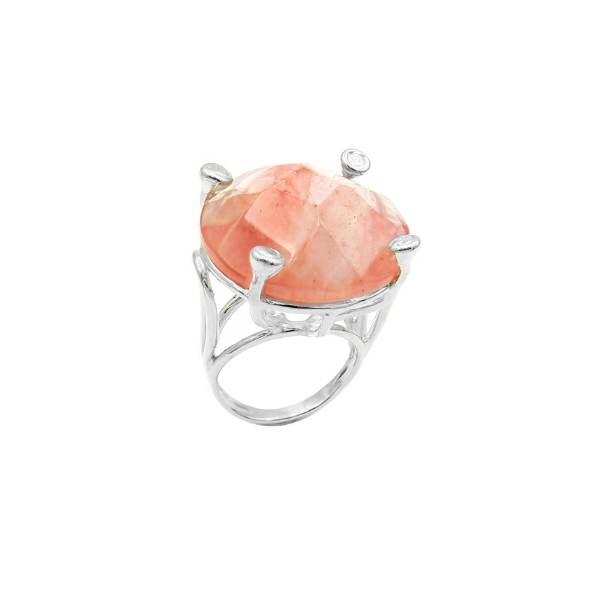 טבעת כסף בעבודת יד, משולבת באבן רוז קוורץ אובלית בגוון ורוד פנינה, המזכיר עלי כותרת של פרח או ענן של אהבה. האבן ידועה כאבן הלב, מסמלת רכות, קבלה רכה ואנרגיה מרפאת, והיא משדרת אנרגיה רגועה ועדינה. הגימור המלוטש מדגיש את הברק הפנימי שלה ואת האור הפנימי שלה, המשתנה בהתאם לתאורה. השילוב בין הכסף הקריר לבין החום הרגשי של הרוז קוורץ יוצר טבעת עם תחושת עומק רגועה. מתאימה לכל אישה שמחפשת חיבור עדין לרגש, מתנה עם מסר, או מתנה אישית עם משמעות ואהבה.