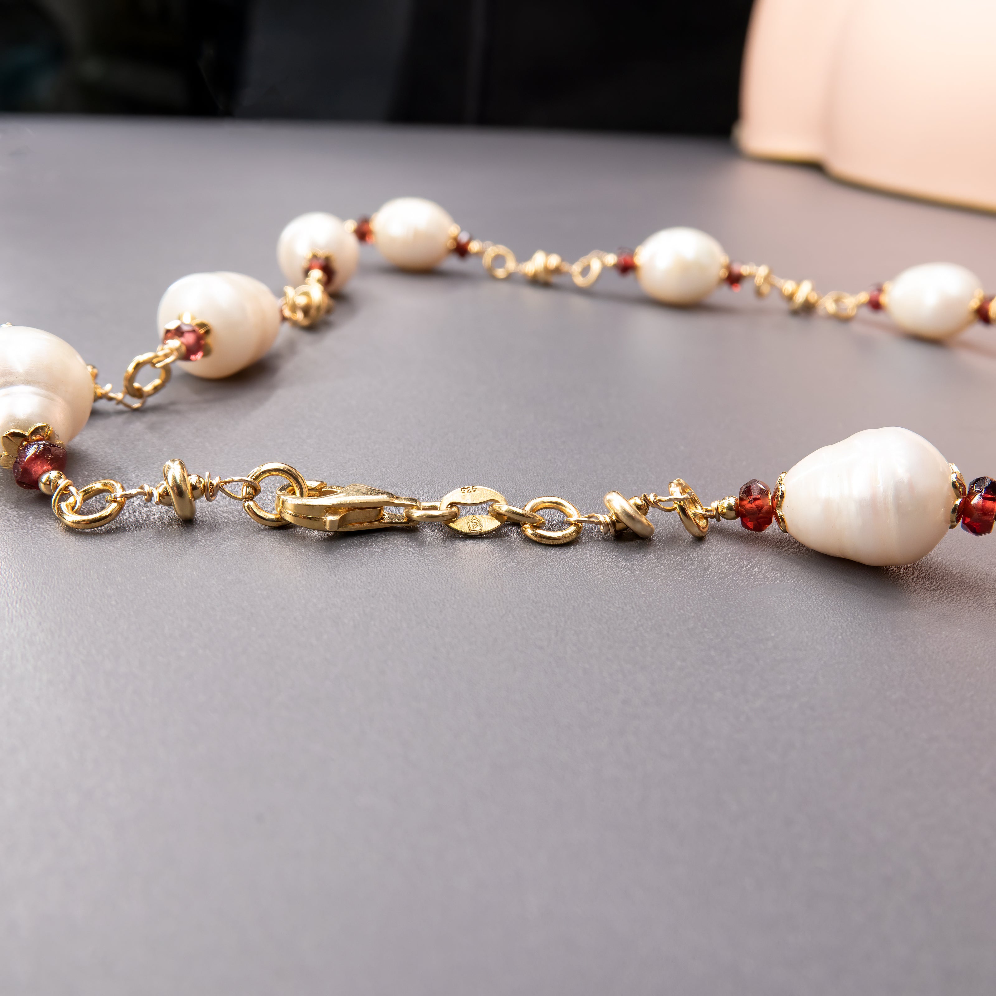 שרשרת אלגנטית המשלבת פנינים לבנות טבעיות עם גארנטים בגוון יין עמוק – ניגוד מרתק בין קלילות לעומק. הפנינים מעניקות לשרשרת זוהר פנימי בגוון לבן טהור, בעוד שהגארנטים מוסיפים עומק צבע ועומק גווני אדום כהה עם נגיעה דרמטית. התוצאה היא מראה עשיר, מאוזן והרמוני, שמתאים לנשים שאוהבות אלגנטיות עם אופי. השרשרת יכולה להשתלב במראה ערב יוקרתי או לשדרג הופעה יומיומית בנגיעה של צבע ואצילות. בחירה מושלמת למי שמחפשת שרשרת שמחברת רגש, צבע וסגנון.