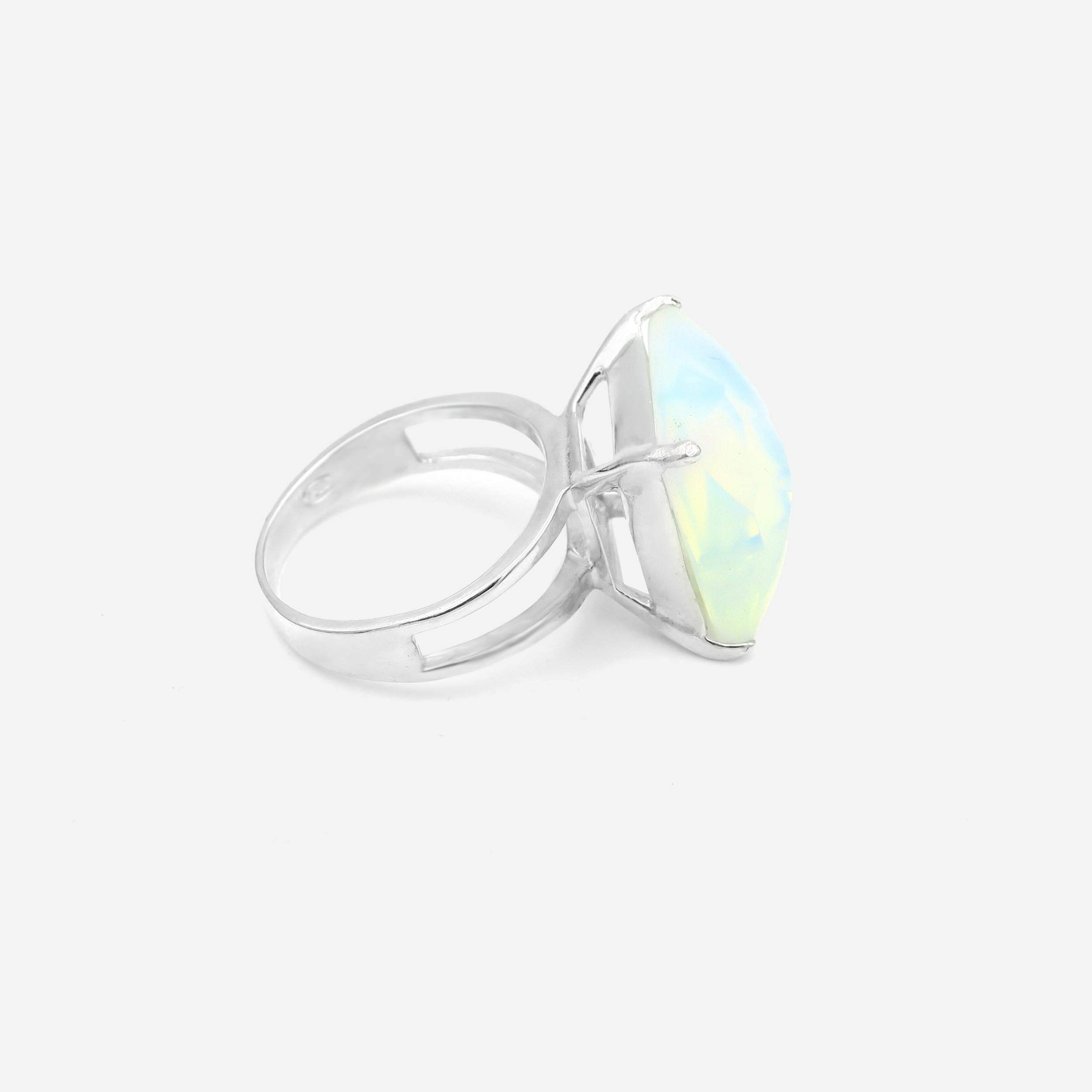 טבעת כסף בעבודת יד, משולבת באבן אופליט לבנה אובלית בעלת מראה חלק ועדין. האבן הלבנה משדרת ברק עדין, עם צבע לבן־ענן שמשתנה בהתאם לזווית התאורה – לעיתים כמעט שקוף, לעיתים בוהק כקרן ירח. הטבעת משלבת עיצוב מינימליסטי עם אופי עדין ובולט. השיבוץ הנקי והחלק מדגיש את יופייה הטבעי של האבן, ויוצר תכשיט שמביא איתו איזון, בהירות ועדינות. המתכת הכסופה והברק הפנימי של האופליט משתלבים למראה שמשדר איזון בין אלגנטיות קלאסית לרוח מודרנית רגישה. טבעת שמתאימה לאירועים חגיגיים או ליום־יום עם נגיעה אישית ומיוחדת. תכשיט שמתחבר לתח