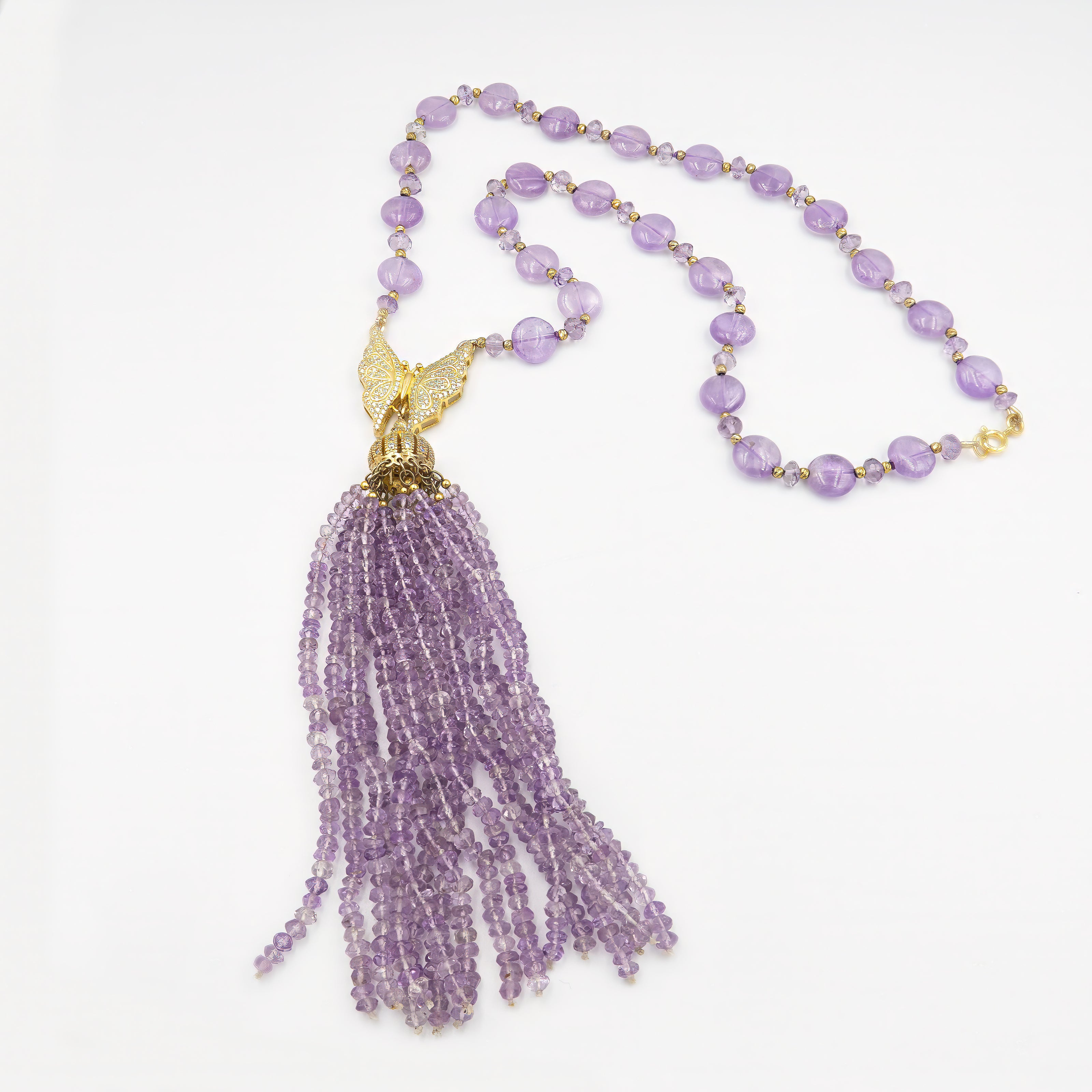 שרשרת ארוכה בעבודת יד, עשויה מאבן אמטיסט רכה בטון טבעי, בגוון סגול שקוף־ענברי עדין, עם תליון כסוף מנצנץ בקצה. החרוזים יוצרים נוכחות עדינה אך בולטת, עם תחושת קלילות ואלגנטיות בתנועה. השרשרת מתאימה למראה ערב רומנטי, לאירוע חגיגי או אפילו ללבוש יומיומי שזקוק לנגיעה של קסם. האמטיסט נחשב לאבן של רוגע ואינטואיציה, והעיצוב כולו משדר מפגש בין קלילות ופואטיקה. תכשיט עם אווירה נשית, מעודנת ומלאת הבעה – כזה שלא צריך מילים כדי לומר שהוא מיוחד.