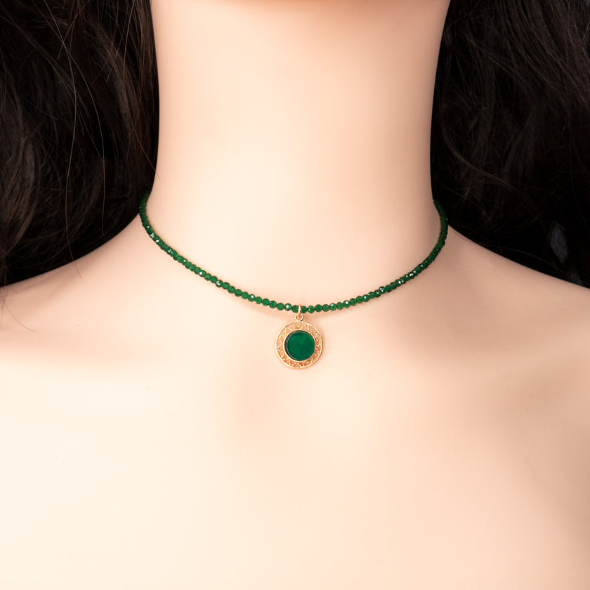 קולר ירוק עם תליון מוזהב שנושא אבן ירוקה – תכשיט שמזכיר איזון, קרקוע וחיבור לאדמה. צבע האבן מסמל צמיחה והתחדשות, בעוד הזהב מביא איתו חמימות וזוהר. מונח על צוואר נקי, עם בגד לבן שמדגיש את הצבעים והסמליות. מתנה נהדרת לאוהבי אנרגיה חיובית.

