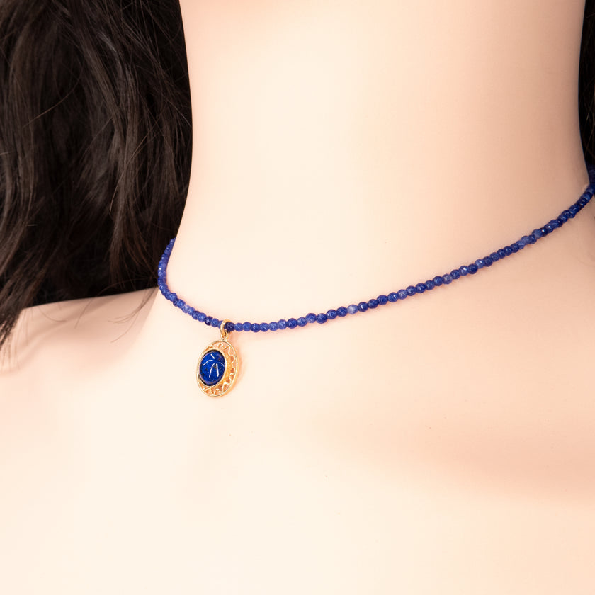 צ’וקר שהוא לא רק תכשיט – אלא הצהרה. חרוזים כחולים עמוקים יוצרים מסגרת מושלמת לתליון מוזהב עם אבן שמהפנטת במבט ראשון. פשוט, מדויק, אלגנטי – בדיוק מה שאת צריכה כדי להפוך כל מראה ליוקרתי ועדכני. תוספת מושלמת לשמלת ערב כהה, ג’קט לבן או אפילו טי-שירט יומיומית שמבקשת טאץ’ של סטייל אישי.