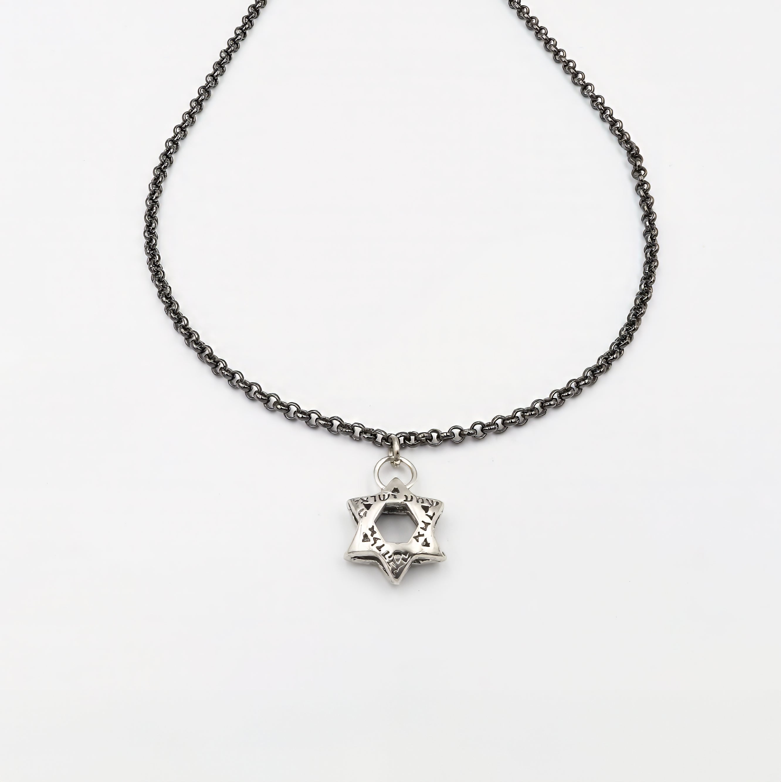 שרשרת כסף יוקרתית לגבר, בגימור רותניום חלק ומוקפד, ללא אבנים. במרכז השרשרת תליון מגן דוד בעיצוב גאומטרי מדויק, המשדר נוכחות סמלית ומודרנית. המראה המתכתי הכהה מעניק לתכשיט עיצוב בולט אך מאופק, המתאימה לגבר שמחפש אמירה ברורה עם מראה עדכני ומוקפד. העיצוב הנקי משתלב בצורה מושלמת עם מגוון סגנונות לבוש – יומיומי או אלגנטי – ומשדר קו מאופק עם תוכן עמוק. שרשרת עם ערך רגשי ועיצוב מדויק, כסמל זהות או כאביזר שמשלים הופעה עם עומק וסיפור.