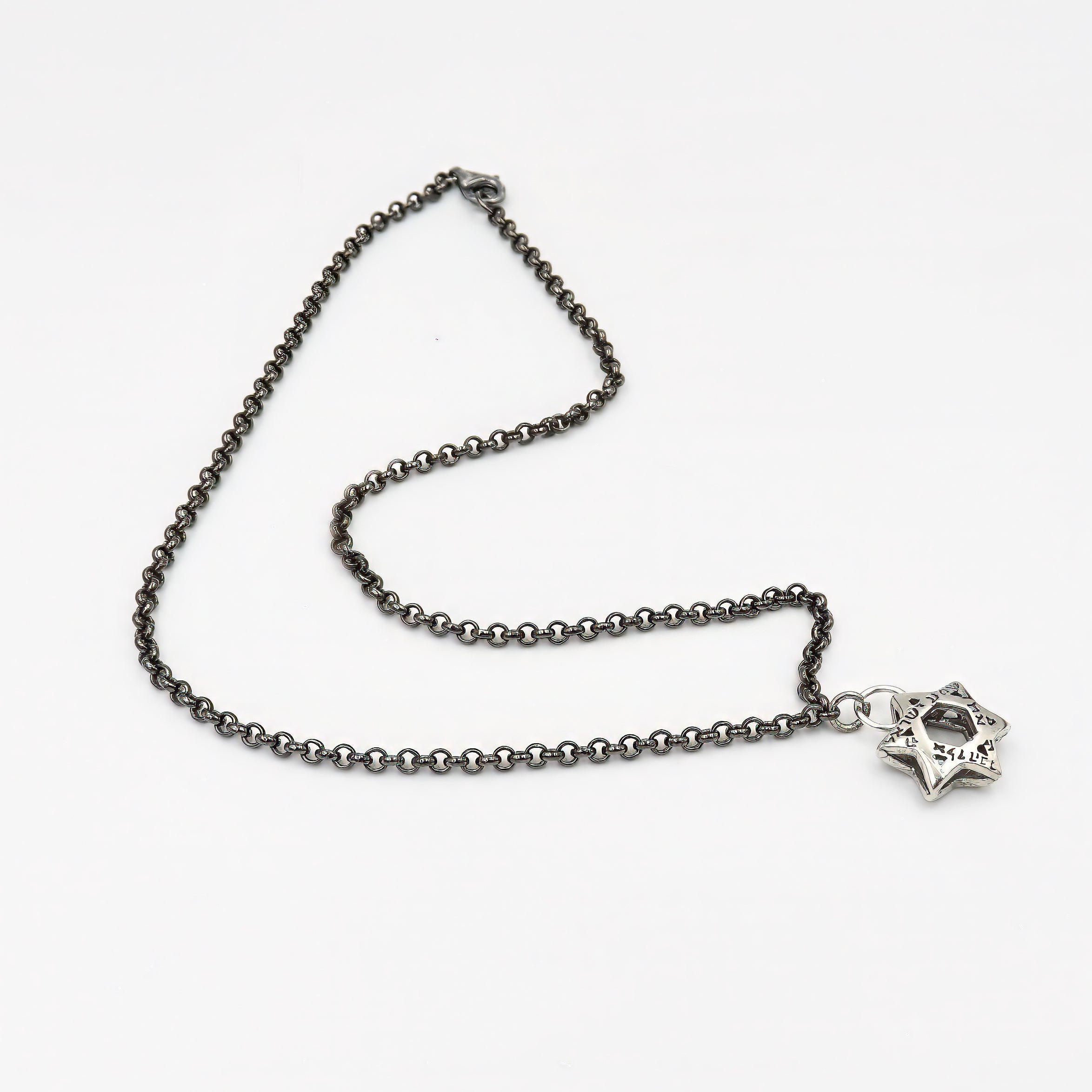 שרשרת כסף יוקרתית לגבר, בציפוי מתכתי כהה במראה עכשווי, ללא אבנים. במרכז השרשרת תליון מגן דוד בעיצוב גאומטרי מדויק, המשדר עומק רוחני וזהות אישית. המראה המתכתי הכהה מעניק לתכשיט מראה עוצמתי ומדויק, המתאימה לגבר שמחפש אמירה ברורה עם מראה עדכני ומוקפד. העיצוב הנקי משתלב בצורה מושלמת עם מגוון סגנונות לבוש – יומיומי או אלגנטי – ומשדר קו מאופק עם תוכן עמוק. שרשרת עם ערך רגשי ועיצוב מדויק, כסמל זהות או כאביזר שמשלים הופעה עם עומק וסיפור.