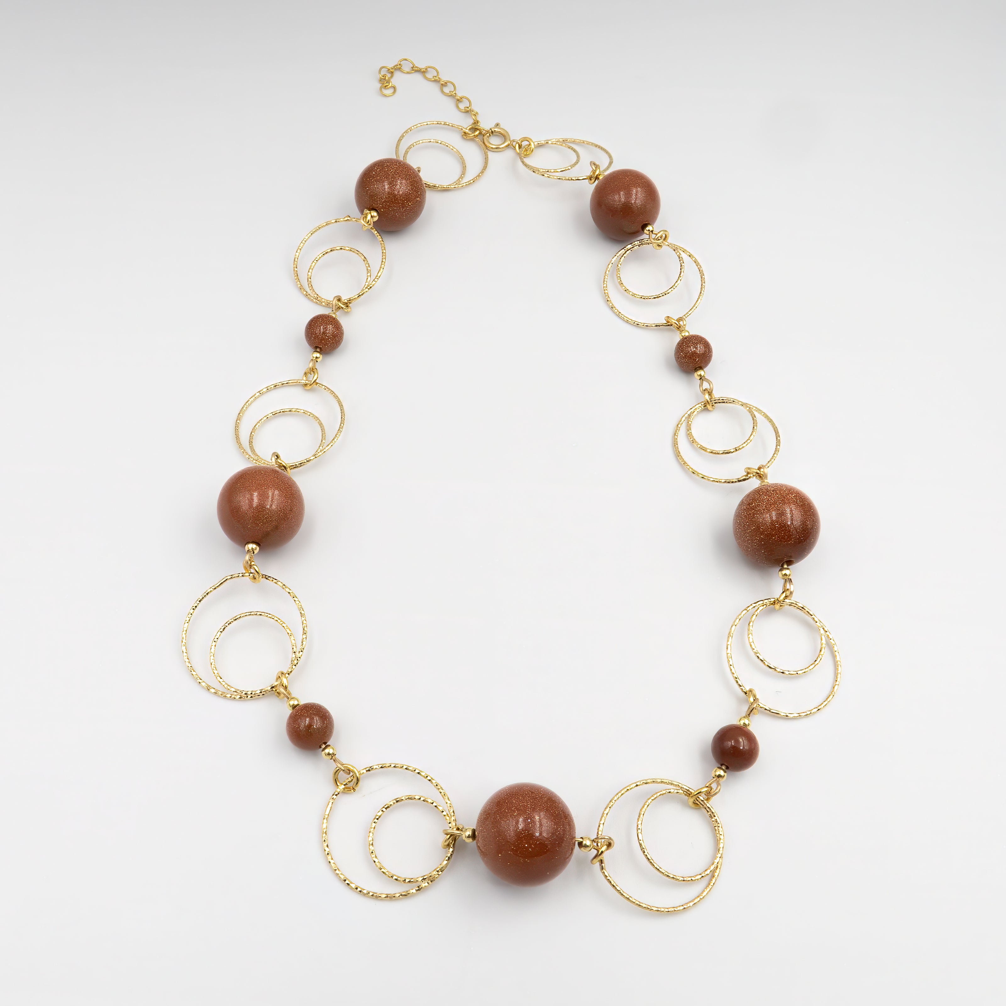 תכשיט אומנותי בגווני חום חמימים – שרשרת עם אבני אוונטיורין בגווני שוקולד, ענבר וקרמל, מבריקים ונעימים למגע. העיצוב מביא תחושת חמימות ושלווה, כמו הליכה בין עלים יבשים בסתיו. תכשיט שמספר סיפור של קרבה לטבע, רכות ויציבות. מתאים לנשים עם סגנון אישי רגוע, שמעריכות עבודת יד מוקפדת ופריטים עם משמעות אנרגטית ונוכחות שקטה אך עמוקה.