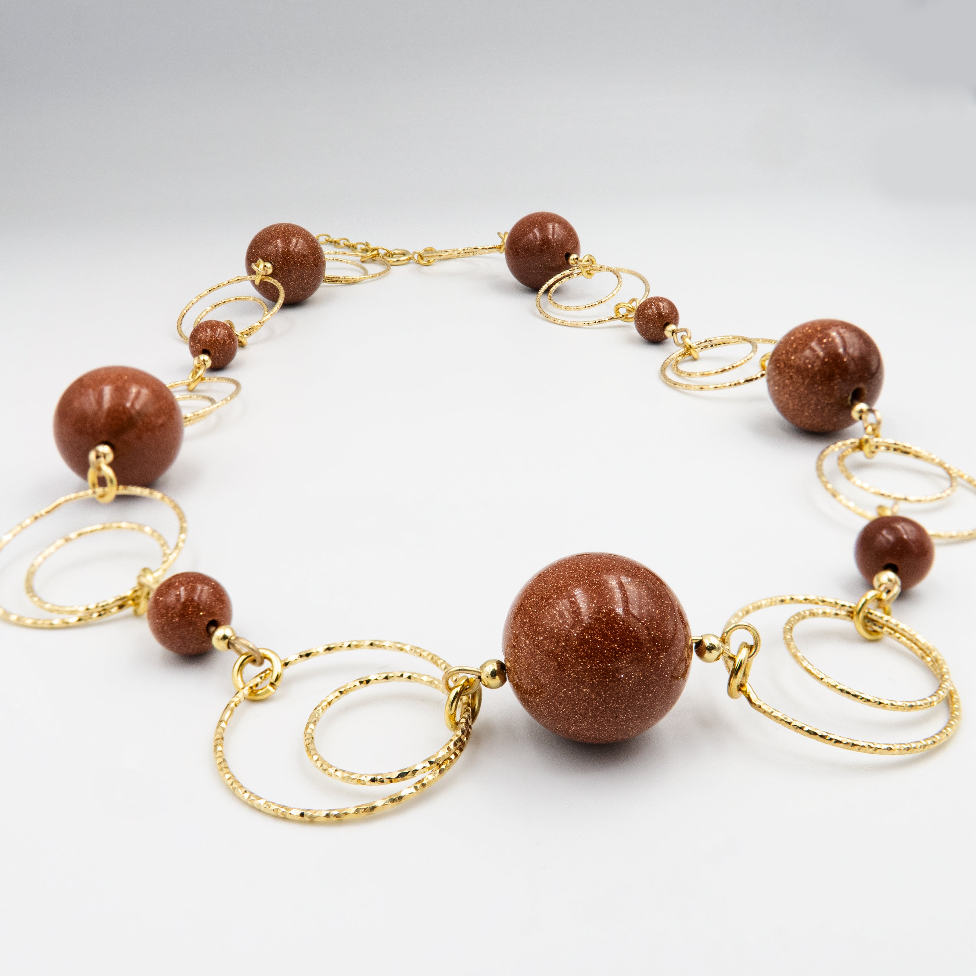 תכשיט מינרלי בעבודת יד עם אבני אוונטיורין חומות בגימור טבעי – חלקן מט וחלקן מבריקות – משולבות זו בזו בהרמוניה מושלמת. צבעי האבן נעים בין חום קפה קלוי ועד חום אדמה עמוק, ומקרינים תחושת נינוחות, שורשיות ובשלות. תכשיט שמתאים ללוק שכבות סתווי, חולצות פשתן רכות וסוודרים בגווני אדמה. קליל לענידה אך מלא בנוכחות ואופי.