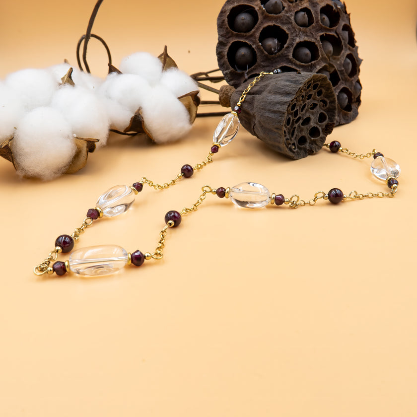 שרשרת זהב 14 קראט עדינה עם תליון כפול: גארנט טבעי בגוון אדום עמוק ורוק־קריסטל מלוטש. עיצוב שמחבר בין הלב לתודעה, בין תשוקה לאור. הזהב החם מדגיש את הברק הטבעי של האבנים ויוצר מראה מאוזן, מלא נוכחות. תכשיט שמחמיא לכל סגנון – קז'ואל, אלגנטי או בוהו־שיק. מתנה עם משמעות רגשית עמוקה – אהבה, ריפוי ואיזון.
