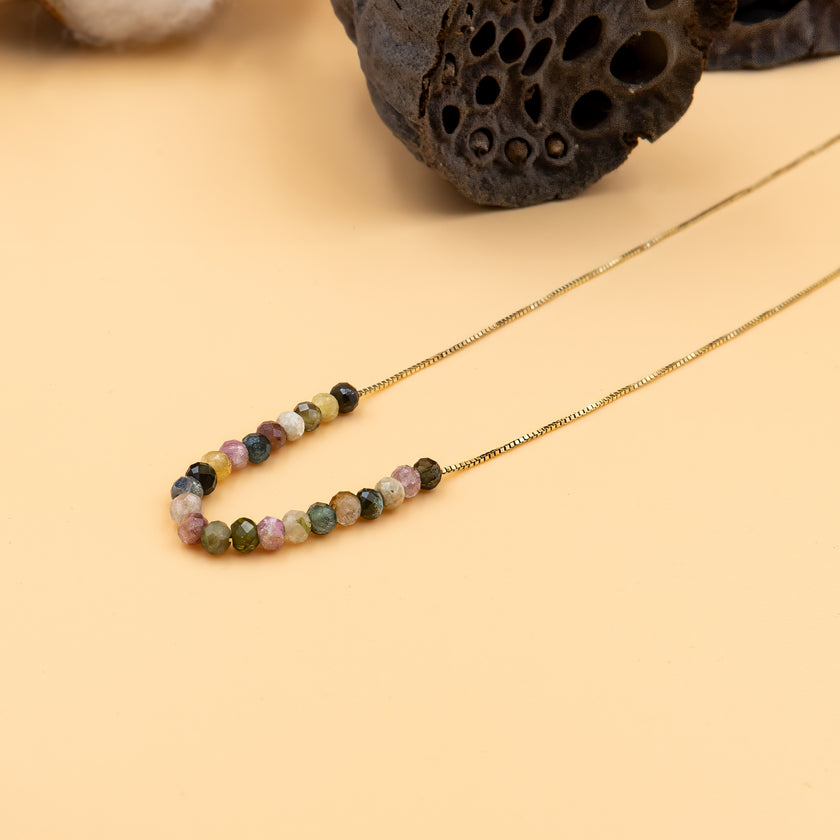 שרשרת צבעונית ואלגנטית עשויה חרוזי טורמלין אמיתיים בגימור חלק ונוצץ, מופרדים ביניהם חרוזי זהב 14 קראט שמוסיפים טאץ’ יוקרתי. כל אבן שונה, והמעבר בין הצבעים יוצר תנועה הרמונית על הצוואר. שרשרת קלאסית עם טוויסט מודרני, מושלמת כמתנה לחג, ליום הולדת, או כתכשיט סמלי עם משמעות אישית. פריט על-זמני שישדרג כל לוק – מסטייל בוהו קליל ועד לשמלה שחורה קטנה.

