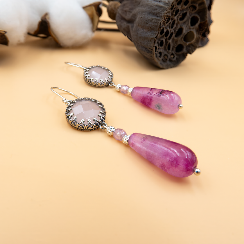 זוג עגילים עדינים עם אבני אופליט ורודות שקופות וטיפת אגת פוקסיה בגוון ורוד עז ומלא חיים, על מסגרת כסף איכותית, המשלבים בין רוך לנועזות, ומתאימים לנשים שמחפשות תכשיט ייחודי עם טאץ' צבעוני ומיוחד.