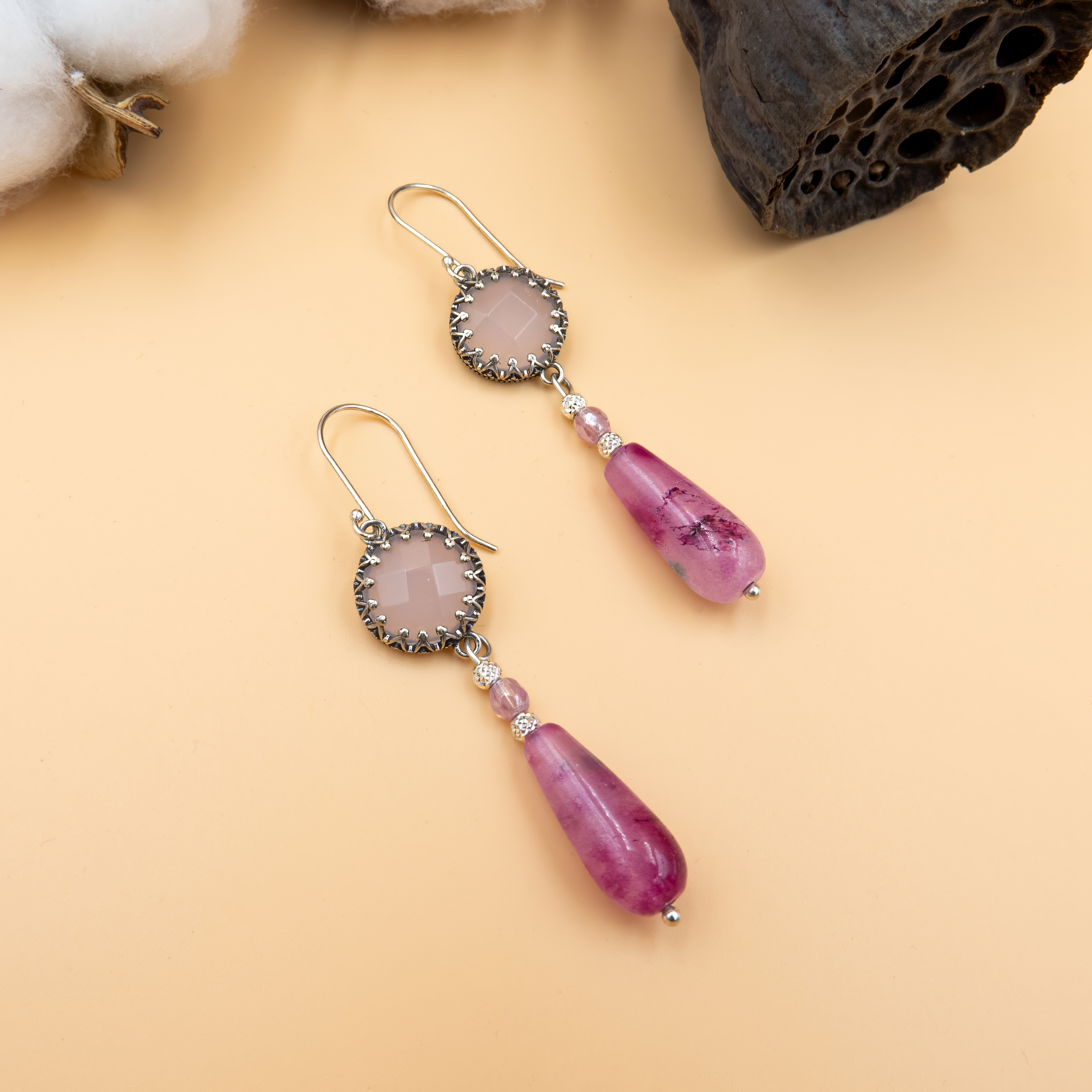 עגילים תלויים בעבודת יד מכסף סטרלינג 925, המשולבים מאבני אופליט בגוון ורוד רך וטיפת אגת פוקסיה בוהקת בצבע ורוד עז, יוצרים תכשיט אלגנטי עם נוכחות רכה ונשית, שמתאים להשלמת כל לוק ביום או בערב.