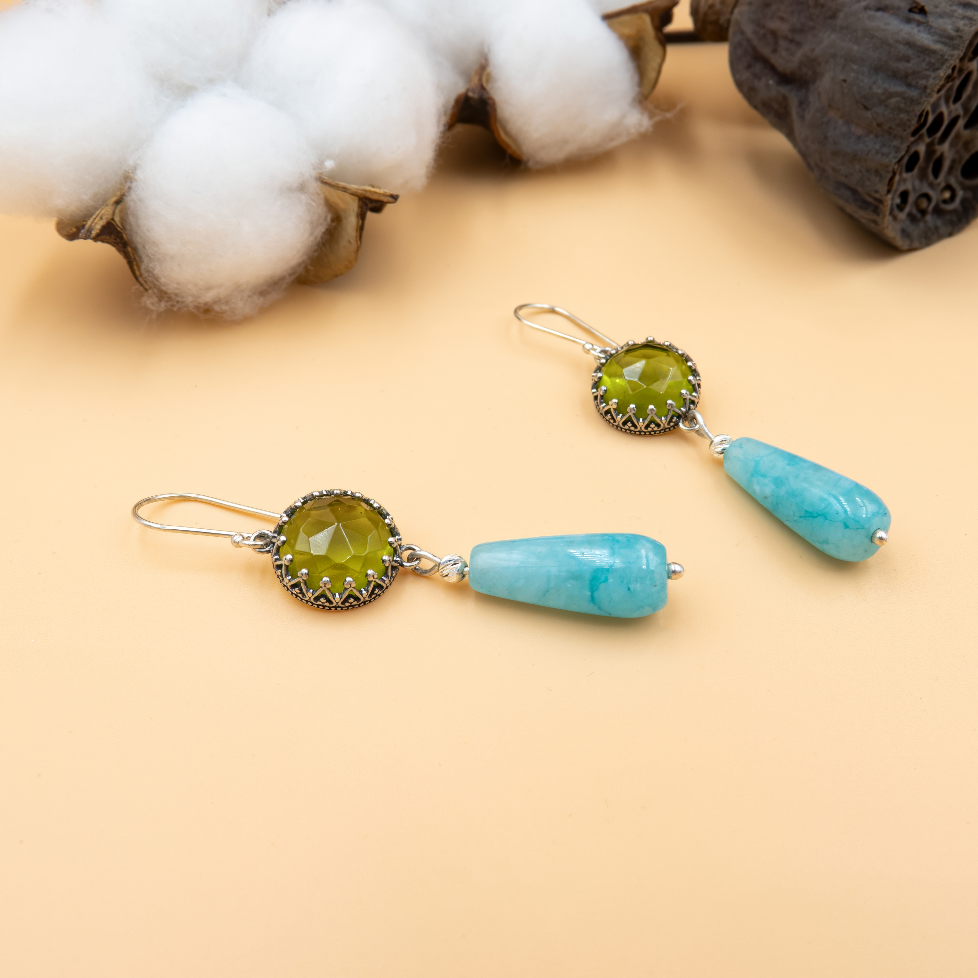 Charming handcrafted earrings with a vintage-inspired silver frame holding a green faceted gem, paired with glossy turquoise teardrop stones. These earrings are full of character—bright, boho, and perfect for everyday flair or special occasions. Their lightweight design ensures comfort while their colors add a refreshing, artistic statement.

