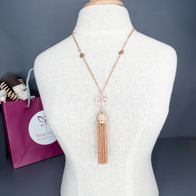 A rose gold tone necklace with a special pendant