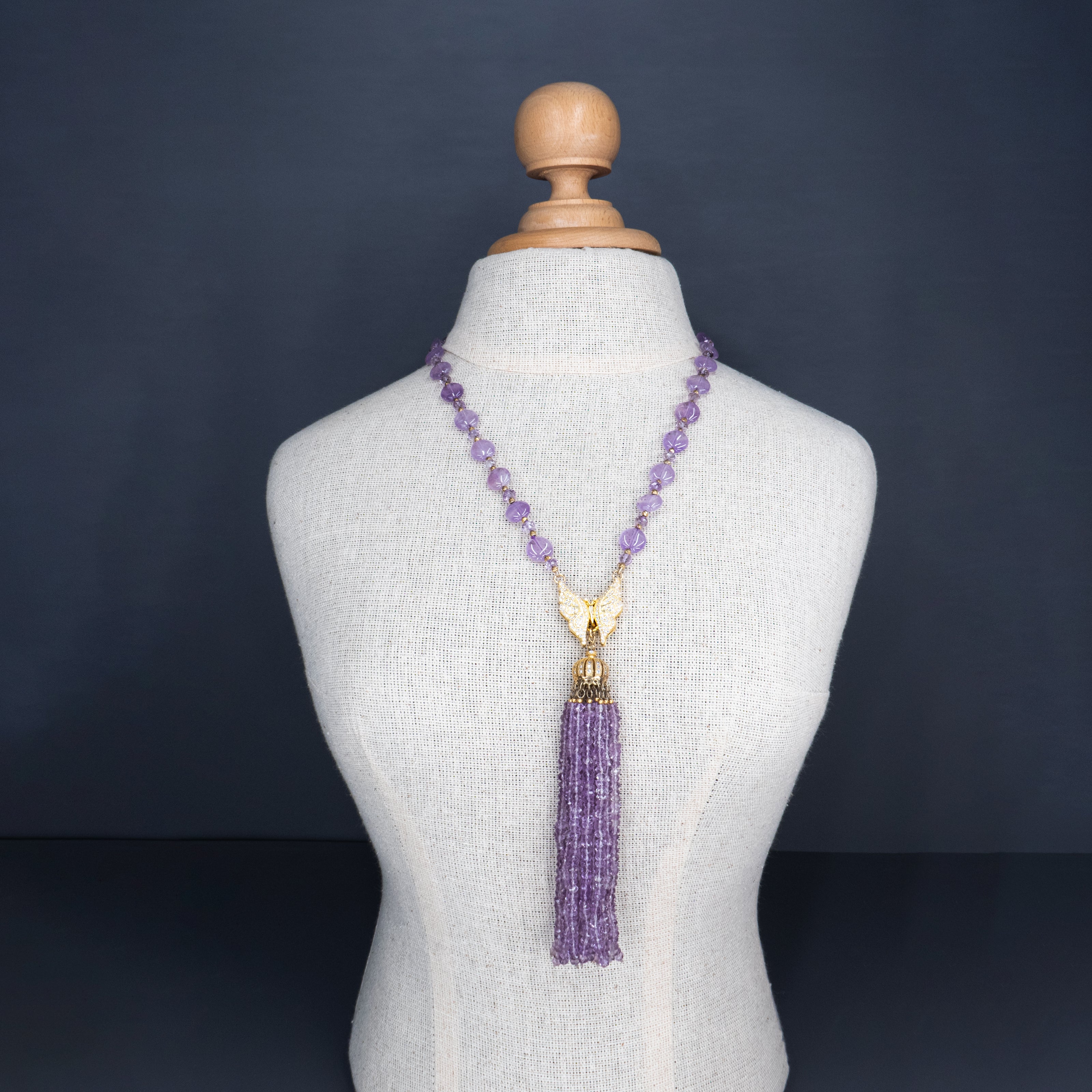 שרשרת ארוכה בעבודת יד, עשויה מחרוזי אמטיסט שקופים בגוון סגול בהיר, בגוון סגול שקוף־ענברי עדין, עם תליון כסוף מנצנץ בקצה. החרוזים יוצרים נוכחות עדינה אך בולטת, עם תנועה חופשית עם ברק עדין. השרשרת מתאימה למראה ערב רומנטי, לאירוע חגיגי או אפילו ללבוש יומיומי שזקוק לנגיעה של קסם. האמטיסט נחשב לאבן של רוגע ואינטואיציה, והעיצוב כולו משדר מפגש בין קלילות ופואטיקה. תכשיט עם אווירה נשית, עדינה עם עומק רגשי – כזה שלא צריך מילים כדי לומר שהוא מיוחד.