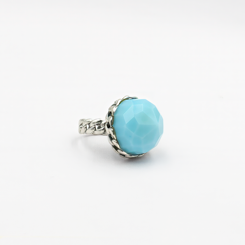 טבעת כסף בעבודת יד, כוללת באבן אופליט אובלית בגוון גוון תכלת פנינתי – צבע שמזכיר שמיים רכים או אור על פני המים. האבן מלוטשת בצורה עגולה חלקה, בעלת שקיפות פנינה קלה ואפקט זוהר פנימי שמתחלף לפי התאורה. הטבעת משדרת עידון, שלווה רגישה ונוכחות שמושכת מבטים בלי להתאמץ. שילוב בין מתכת הכסף הקרה לבין הגוון התכול הרך יוצר איזון בין אור ואלגנטיות, בין אלגנטיות לאור טבעי. מתאימה לנשים שמחפשות אמירה אישית שקטה – רכה אך מדויקת, רגישה אך חזקה. מושלמת כמתנה עם משמעות, פריט יומיומי עם רוך אמנותי, או כתכשיט לאירוע חגיגי באו