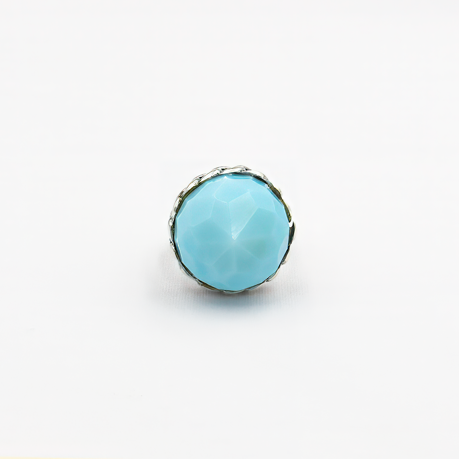 טבעת כסף בעבודת יד, כוללת באבן אופליט אובלית בגוון כחול שמימי – צבע שמזכיר שמיים רכים או אור על פני המים. האבן מלוטשת בצורה עגולה חלקה, בעלת שקיפות פנינה קלה ואפקט זוהר פנימי שמתחלף לפי התאורה. הטבעת משדרת עידון, רוגע עמוק ונוכחות שמושכת מבטים בלי להתאמץ. שילוב בין מתכת הכסף הקרה לבין הגוון התכול הרך יוצר איזון בין אור ואלגנטיות, בין אלגנטיות לאור טבעי. מתאימה לנשים שמחפשות אמירה אישית שקטה – רכה אך מדויקת, רגישה אך חזקה. מושלמת כמתנה עם משמעות, פריט יומיומי עם רוך אמנותי, או כתכשיט לאירוע חגיגי באווירה רגו