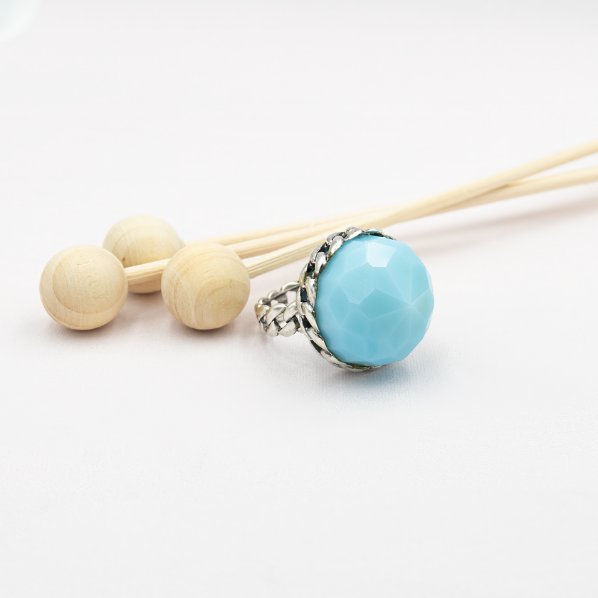 טבעת כסף בעבודת יד, משולבת באבן אופליט אובלית בגוון כחול שמימי – צבע שמזכיר שמיים רכים או אור על פני המים. האבן מלוטשת בצורה עגולה חלקה, בעלת שקיפות פנינה קלה ואפקט זוהר פנימי שמתחלף לפי התאורה. הטבעת משדרת עידון, שלווה רגישה ונוכחות שמושכת מבטים בלי להתאמץ. שילוב בין מתכת הכסף הקרה לבין הגוון התכול הרך יוצר איזון בין עוצמה ועדינות, בין אלגנטיות לאור טבעי. מתאימה לנשים שמחפשות השתקפות פנימית – רכה אך מדויקת, רגישה אך חזקה. מושלמת כמתנה עם משמעות, פריט יומיומי עם קסם רגוע, או כתכשיט לאירוע חגיגי באווירה רגוע