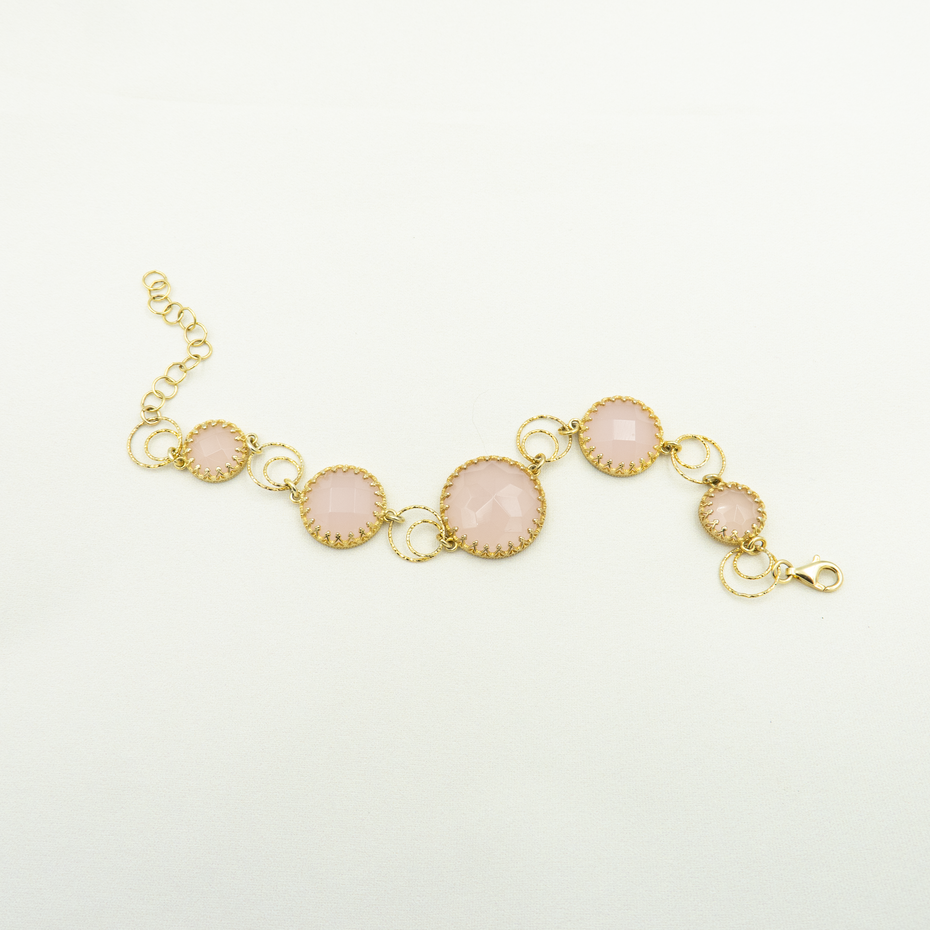 צמיד כסף מצופה זהב עם שיבוץ של אבני אופליט ורודות בגימור פאות מבריק. האבנים העגולות, בגוונים רכים של ורוד חלבי, משובצות במסגרת זהובה עדינה בסגנון תחרה. החוליות העגולות המחברות בין האבנים מוסיפות תנועה קלילה ותחושת רכות נשית. עיצוב רומנטי ויוקרתי שמתאים למראה ערב, מתנה מרגשת או פינוק מיוחד. תכשיט שמשדר רוך, אהבה וסטייל אלגנטי על-זמני.

