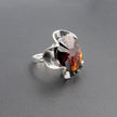 A silver ring combined with a crystal in the shade of garnet