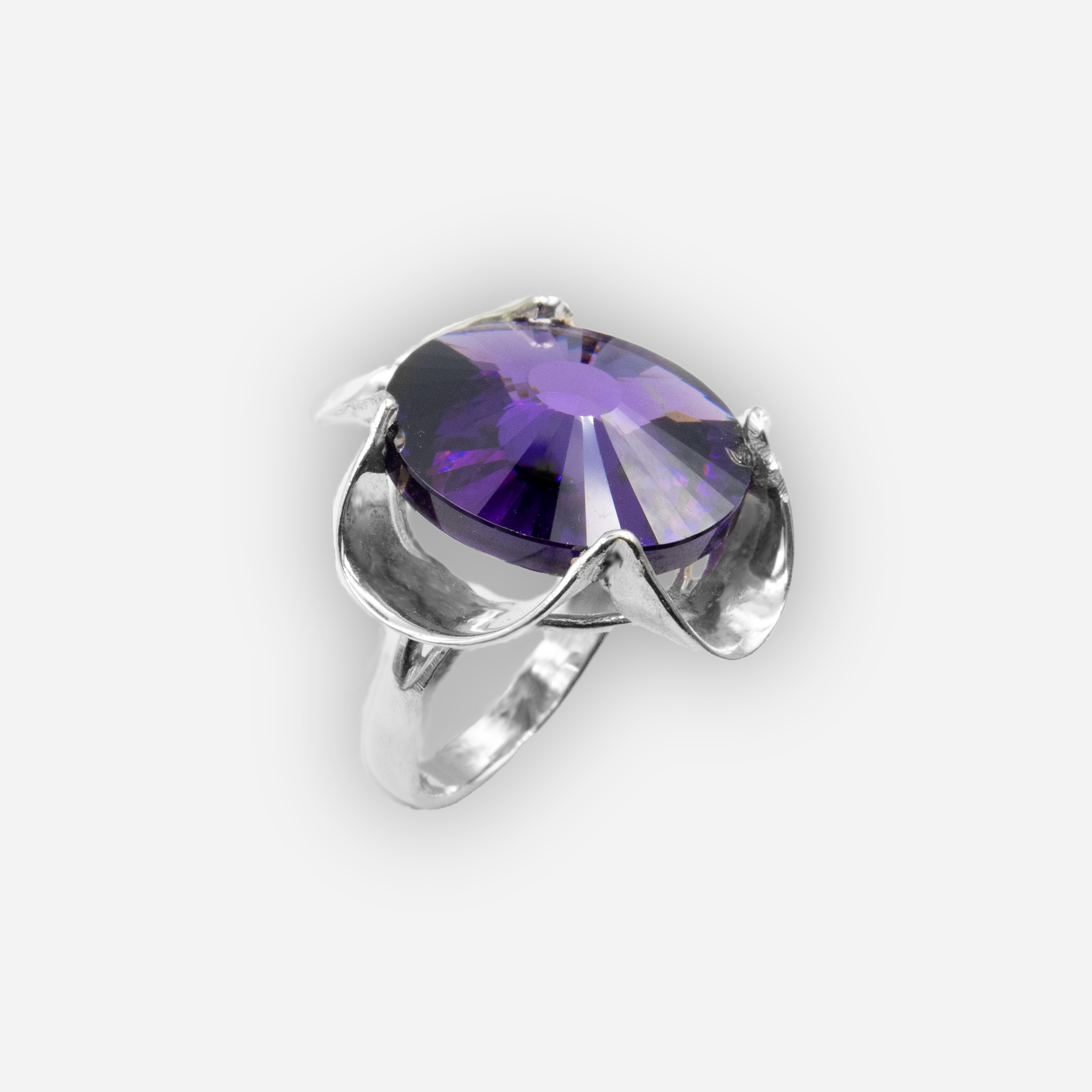 טבעת כסף בעבודת יד, משובצת באבן קריסטל סגולה בגוון המזכיר אמטיסט – צבע עמוק ורוחני שנע בין סגול־לבנדר לצללים של לילך כהה. האבן חתוכה בפאות עדינות ומלוטשת להפליא, מה שמקנה לה ברק פנימי שמושך את העין ומוסיף לתכשיט מראה מלכותי אך לא מתאמץ. השילוב בין גוון האבן העשיר לבין הכסף הנקי יוצר טבעת אלגנטית, שיש בה גם נוכחות וגם רכות. האבן משדרת תחושת עומק רגשי, אינטואיציה ונשיות רגישה. מתאימה לנשים שמחפשות תכשיט עם סמליות, מראה ייחודי ואנרגיה חיובית. פריט שיכול להיות תוספת יומיומית עם ניחוח אישי, או מתנה מרגשת.

